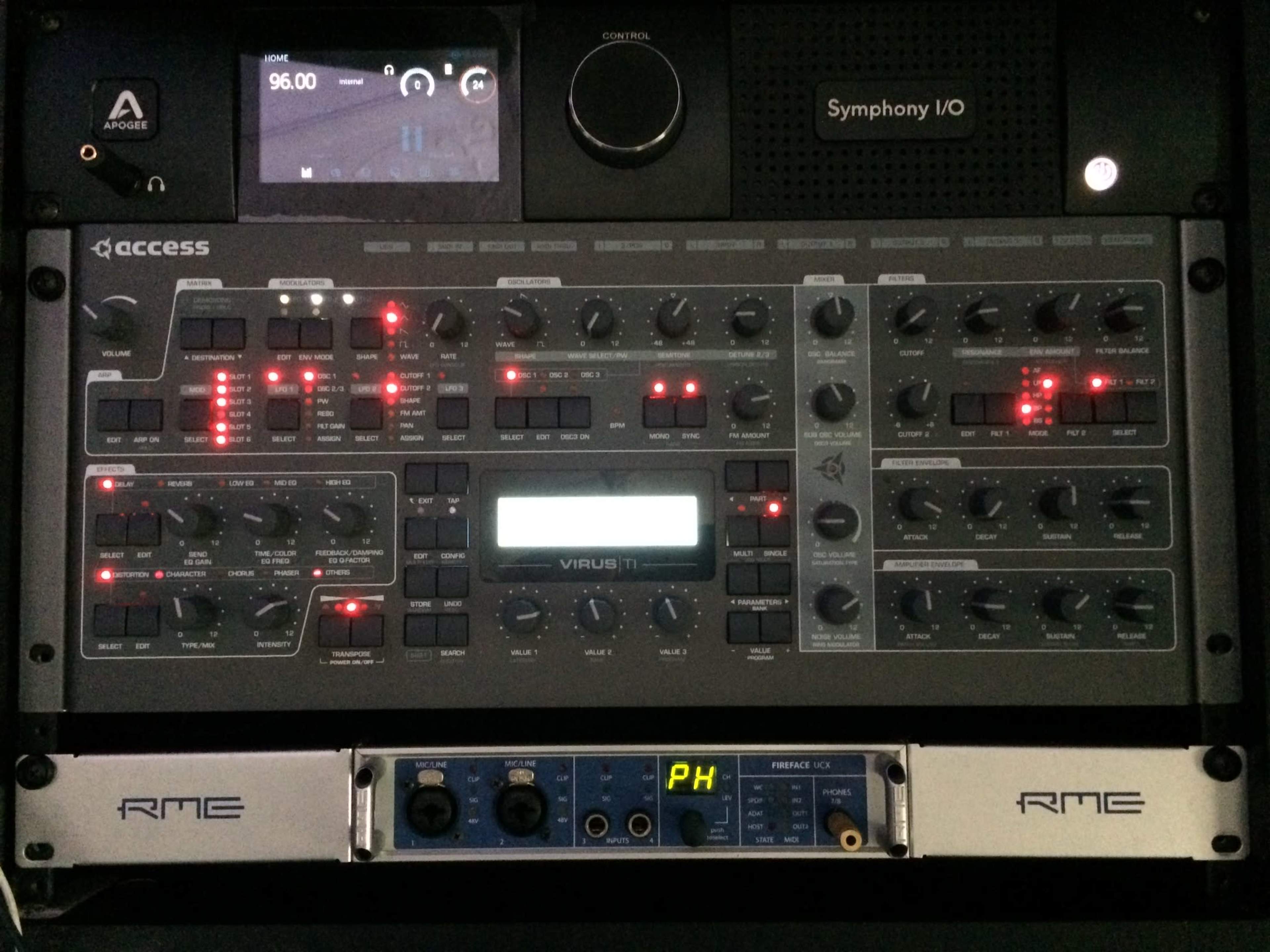 The image shows a digital synthesizer and audio interface setup, featuring various knobs, sliders, and a display screen.