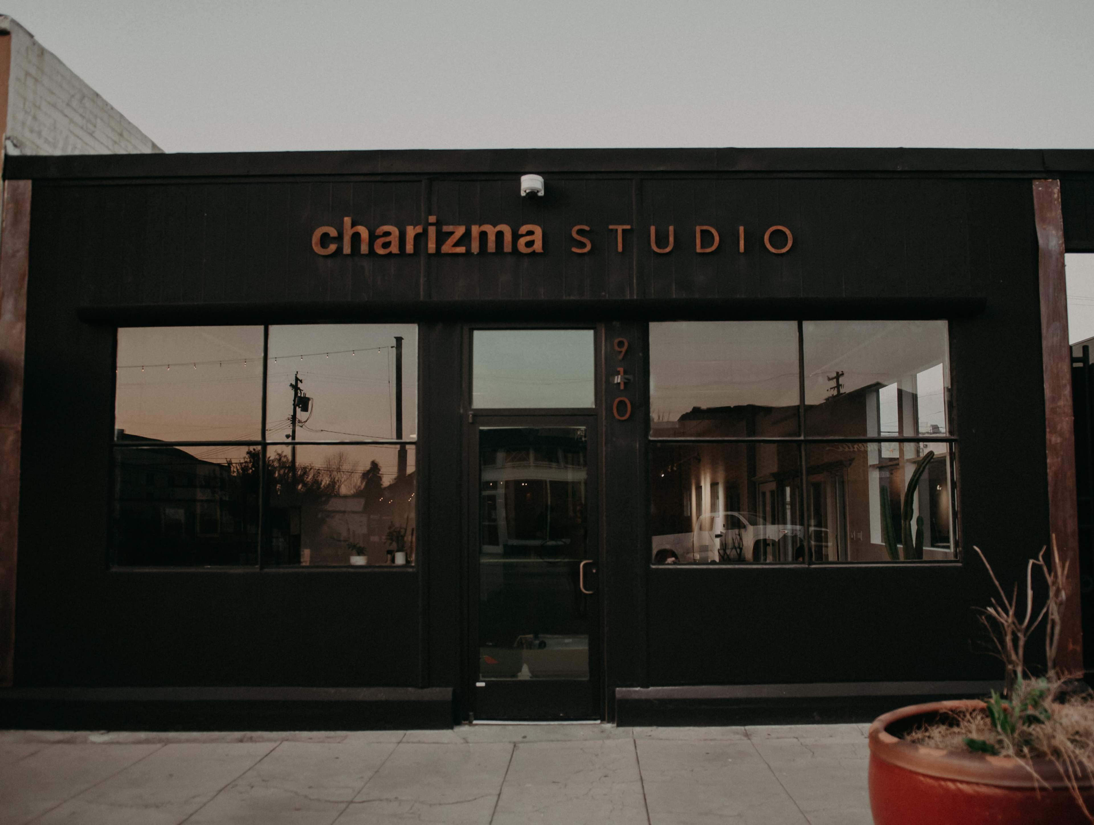 A modern black building with large windows and the name "charizma STUDIO" displayed above the entrance.