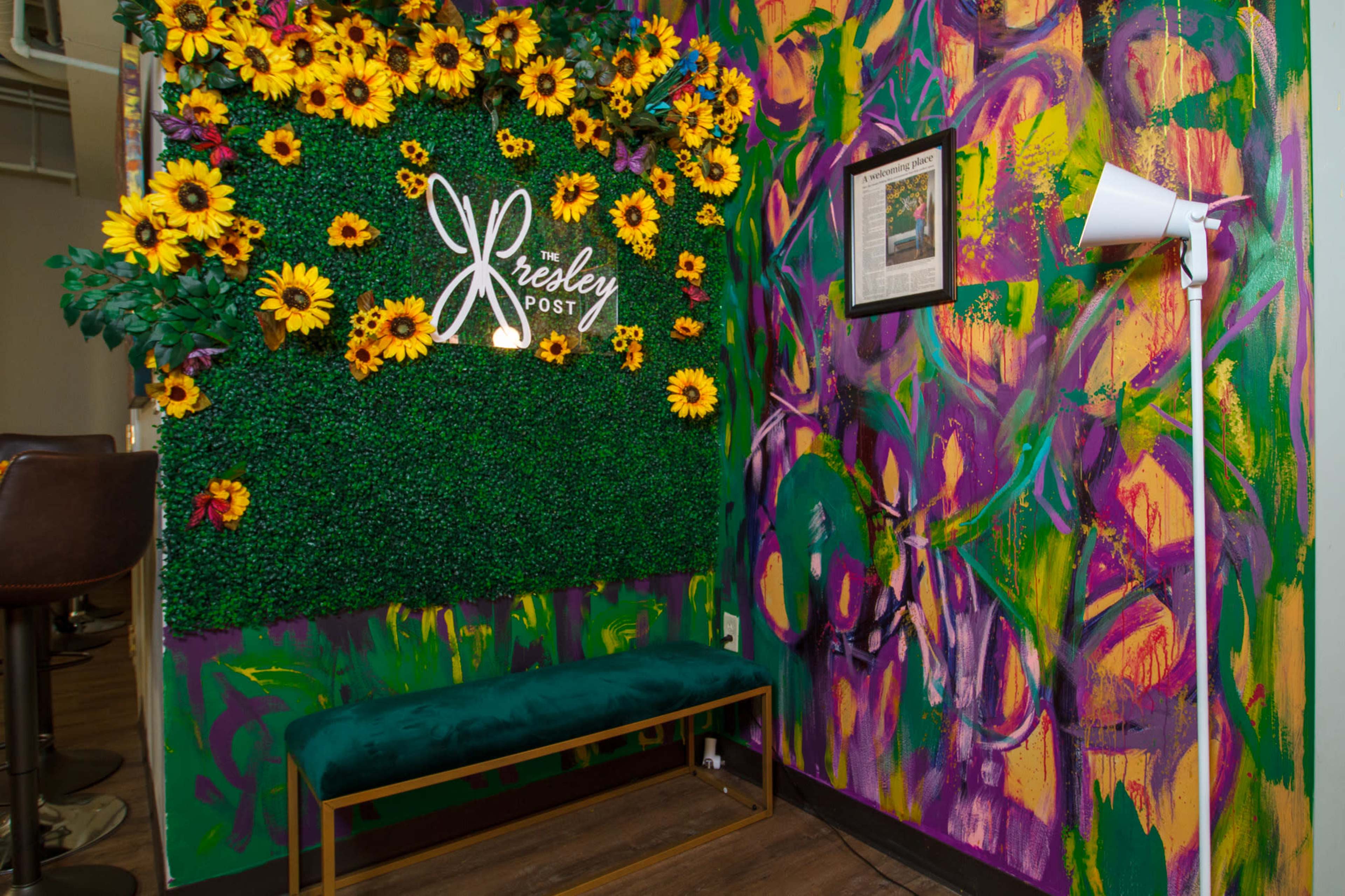 The image shows a vibrant wall covered in colorful paint with a green, flower-adorned backdrop featuring the name "Presley Post."