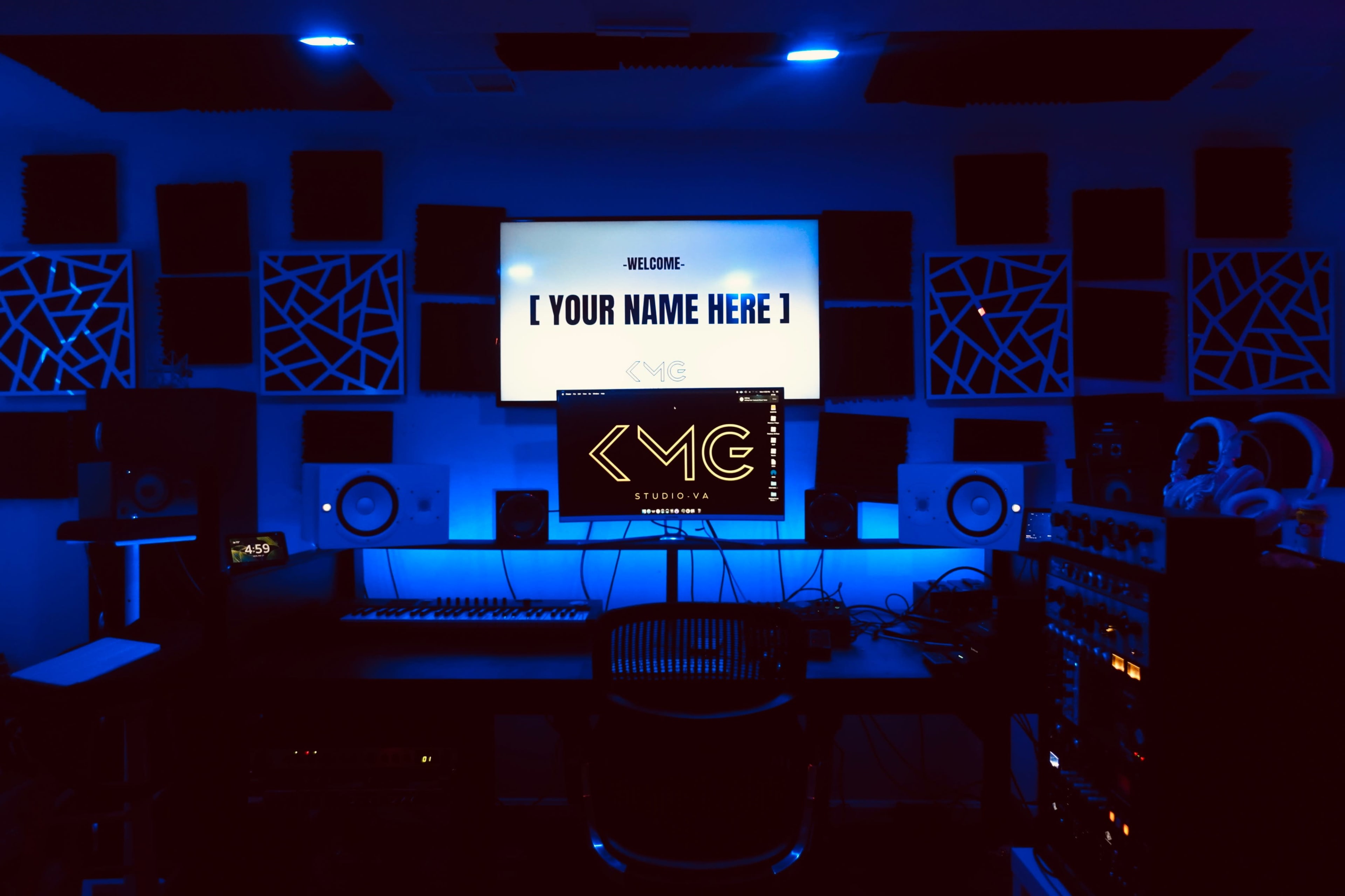The image shows a music studio with a dark ambiance, featuring a large screen with a welcome message, a computer monitor, speakers, and audio equipment illuminated by blue lights.