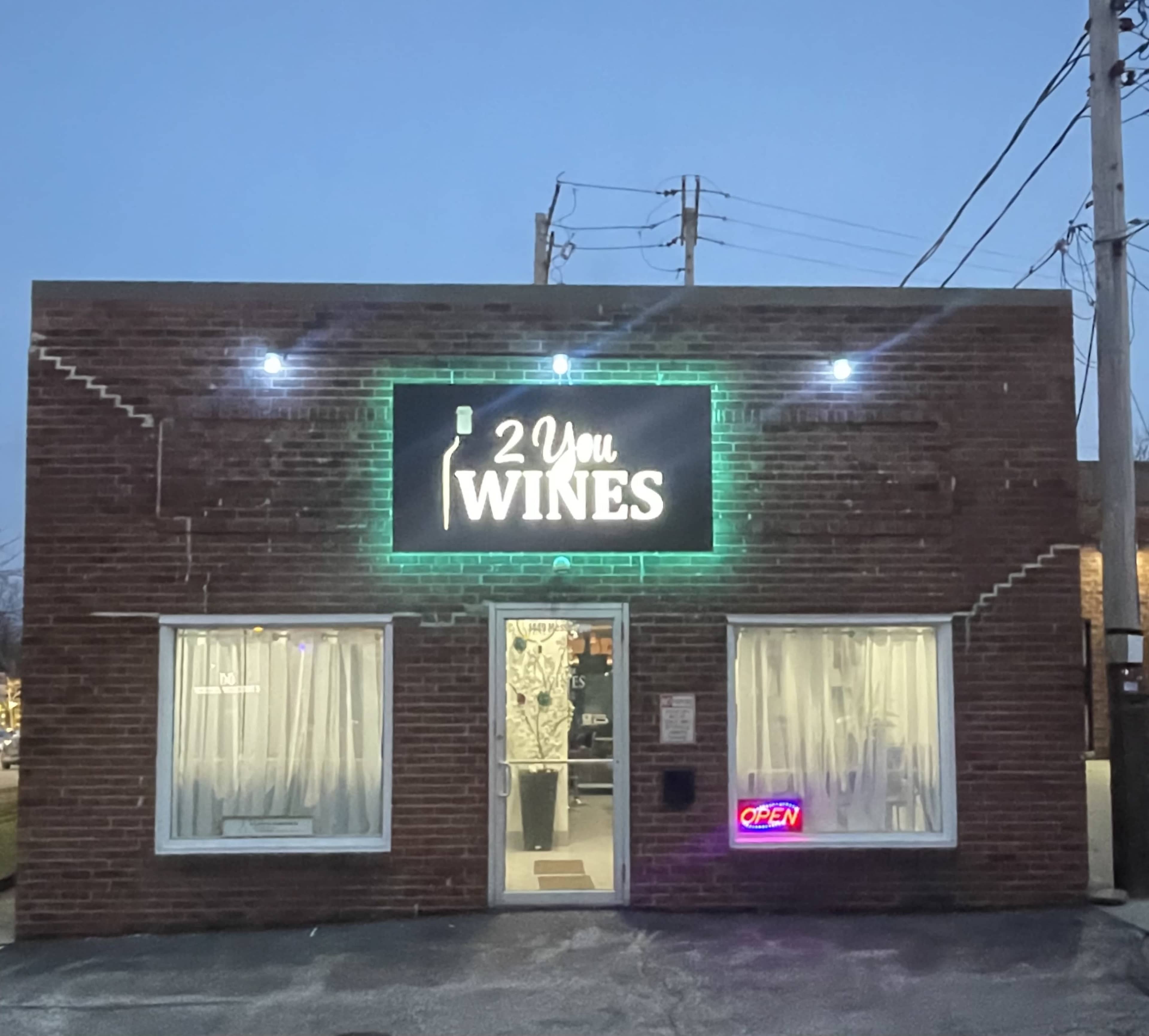 The image shows a brick building with a neon sign that reads "2 You WINES" and an illuminated "OPEN" sign in the window.