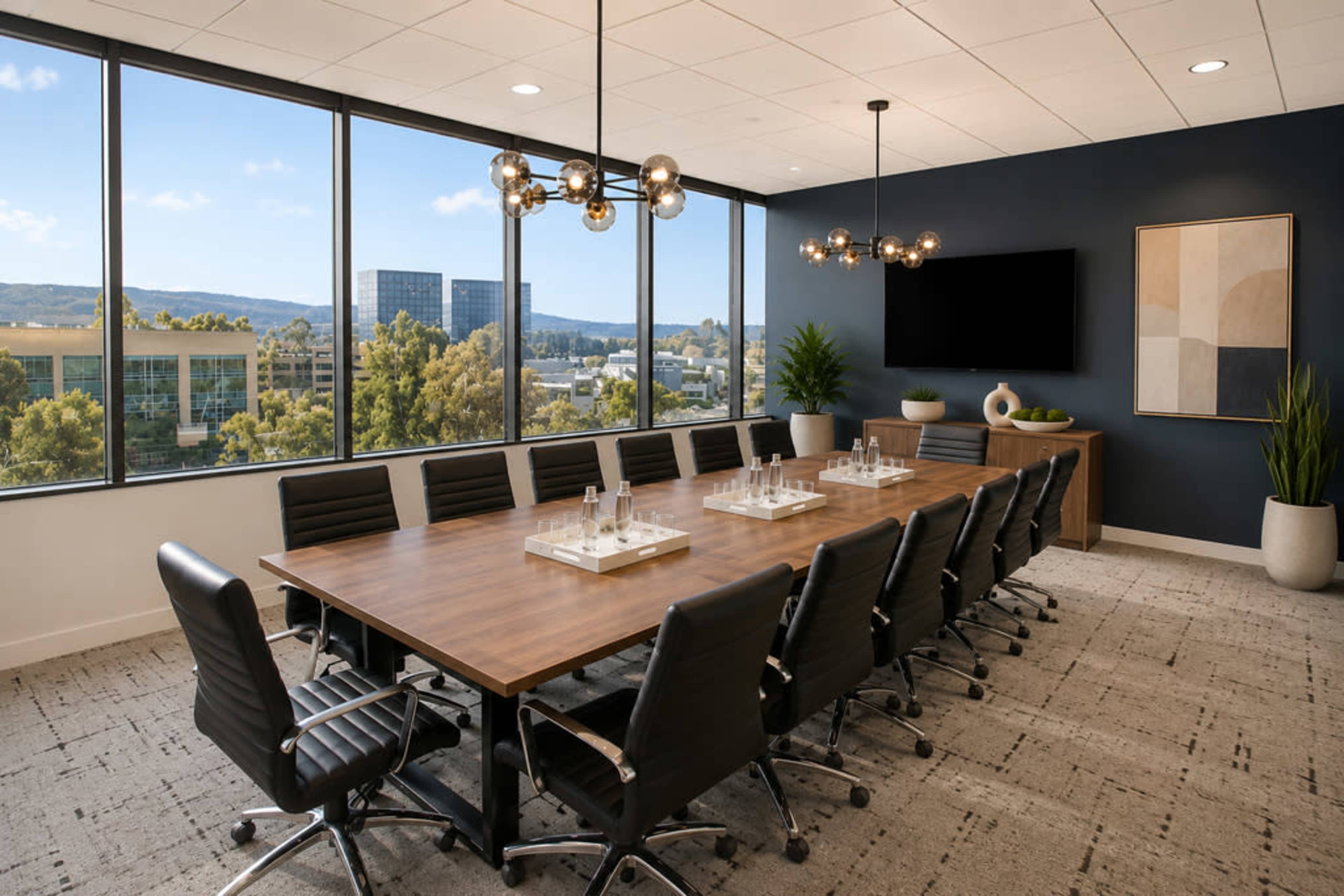 A modern conference room features a large wooden table surrounded by black leather chairs, with large windows offering a view of a cityscape and greenery outside.