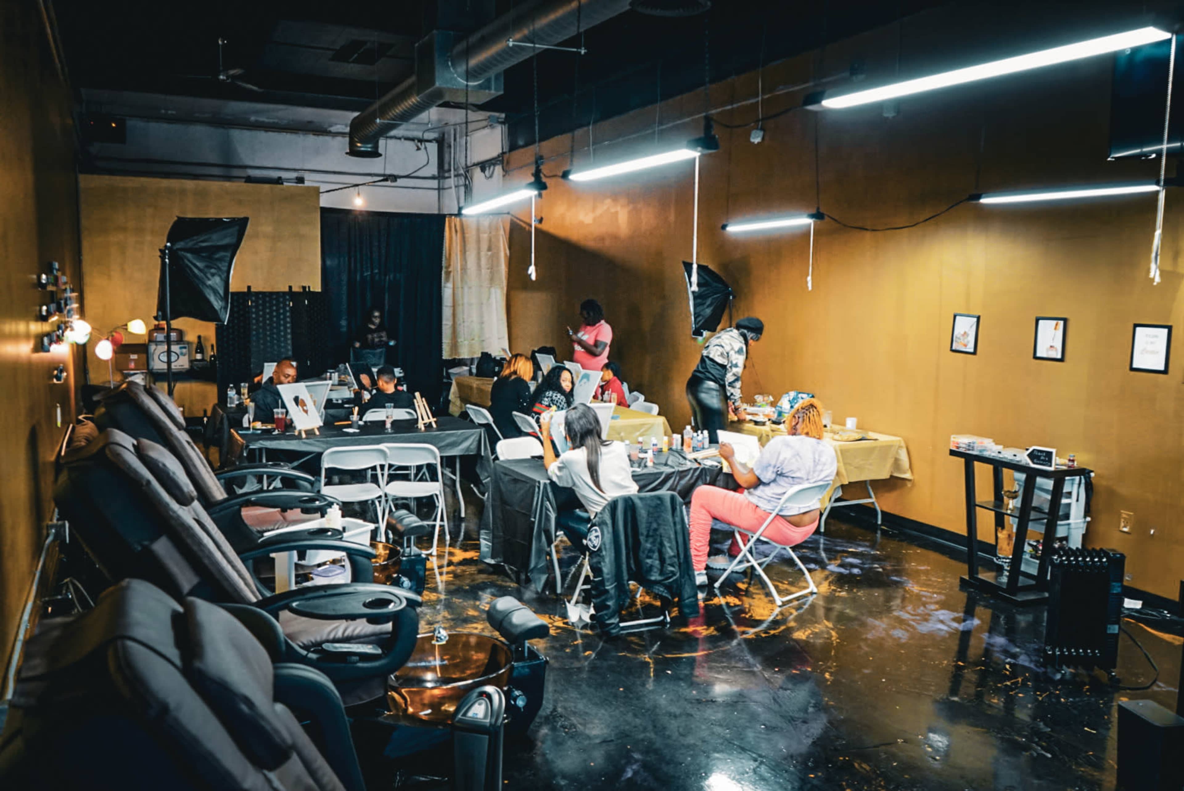 A beauty salon features several clients receiving services while stylists work at stations in a well-lit interior.