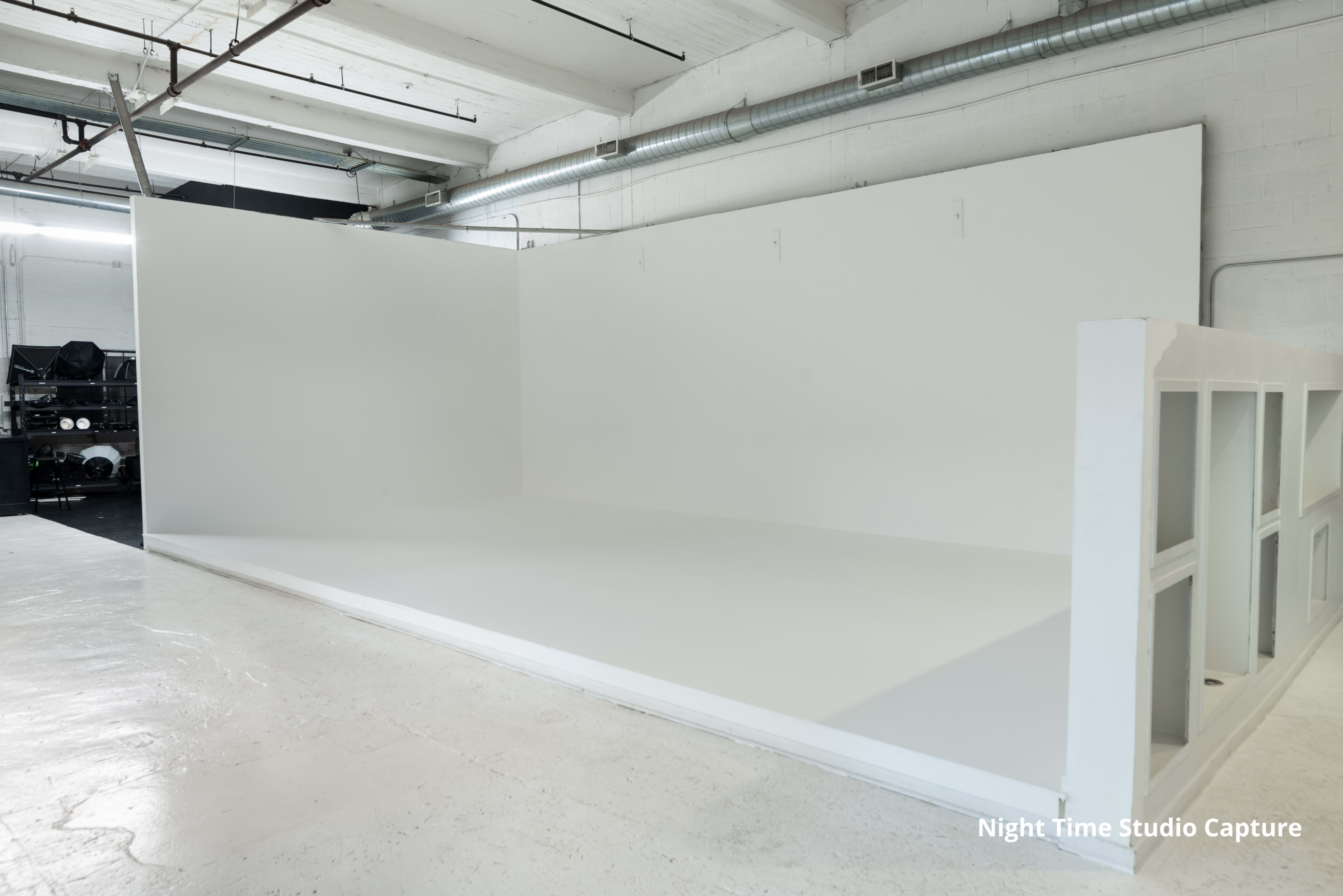 A spacious, minimally decorated studio with white walls and a smooth white floor.