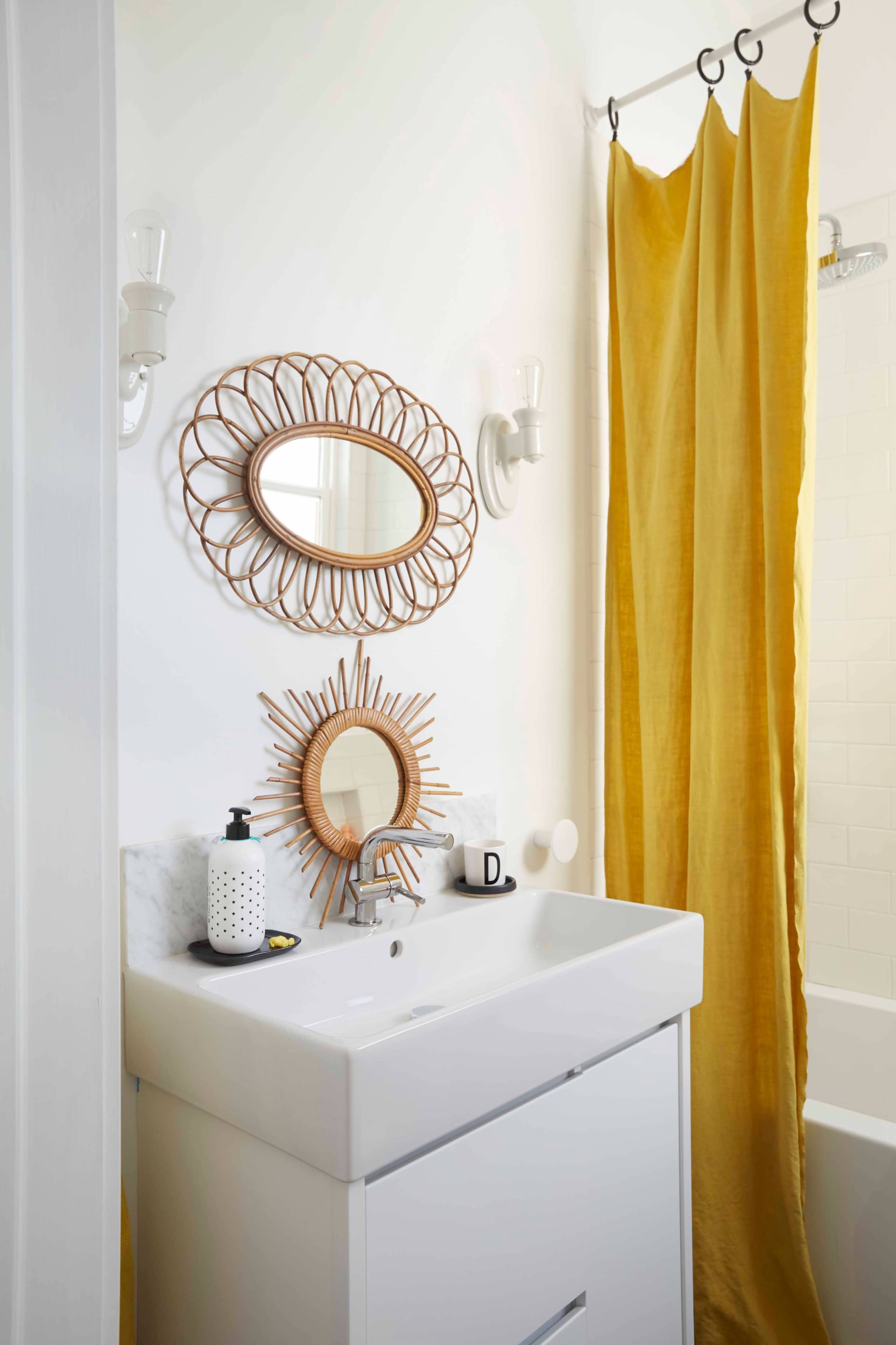 The image features a modern bathroom with a white sink, a large mirror, and a yellow shower curtain.