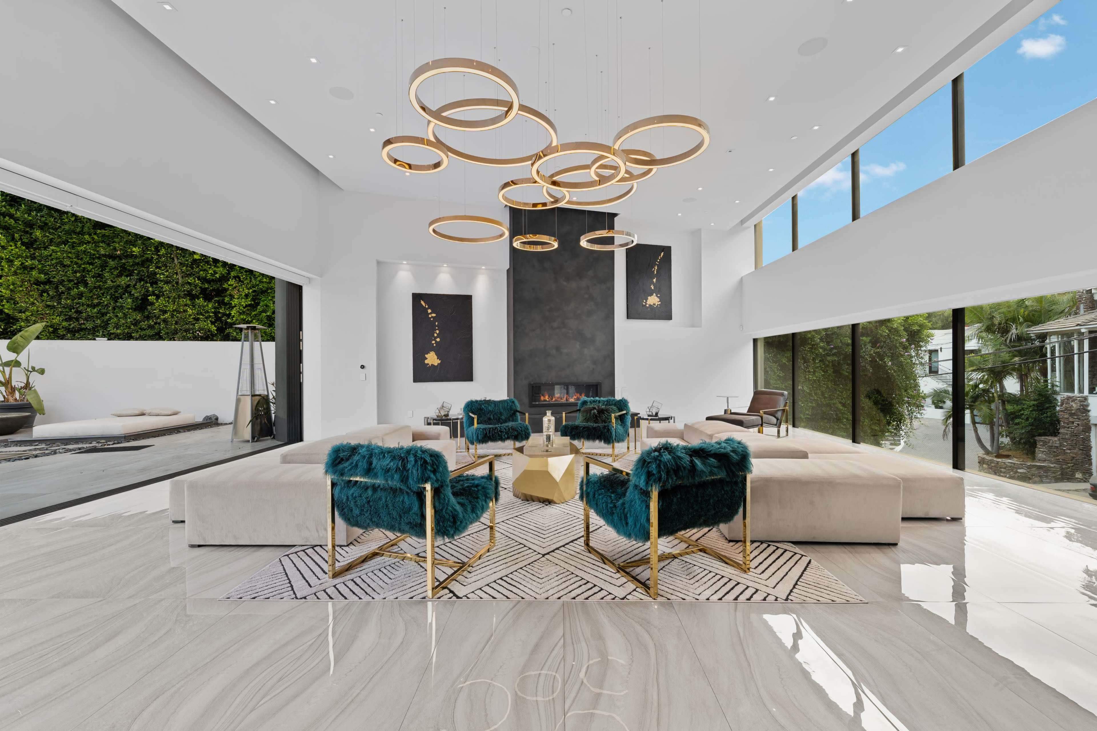 The spacious living room features modern furnishings, sleek marble flooring, and large windows that provide ample natural light.