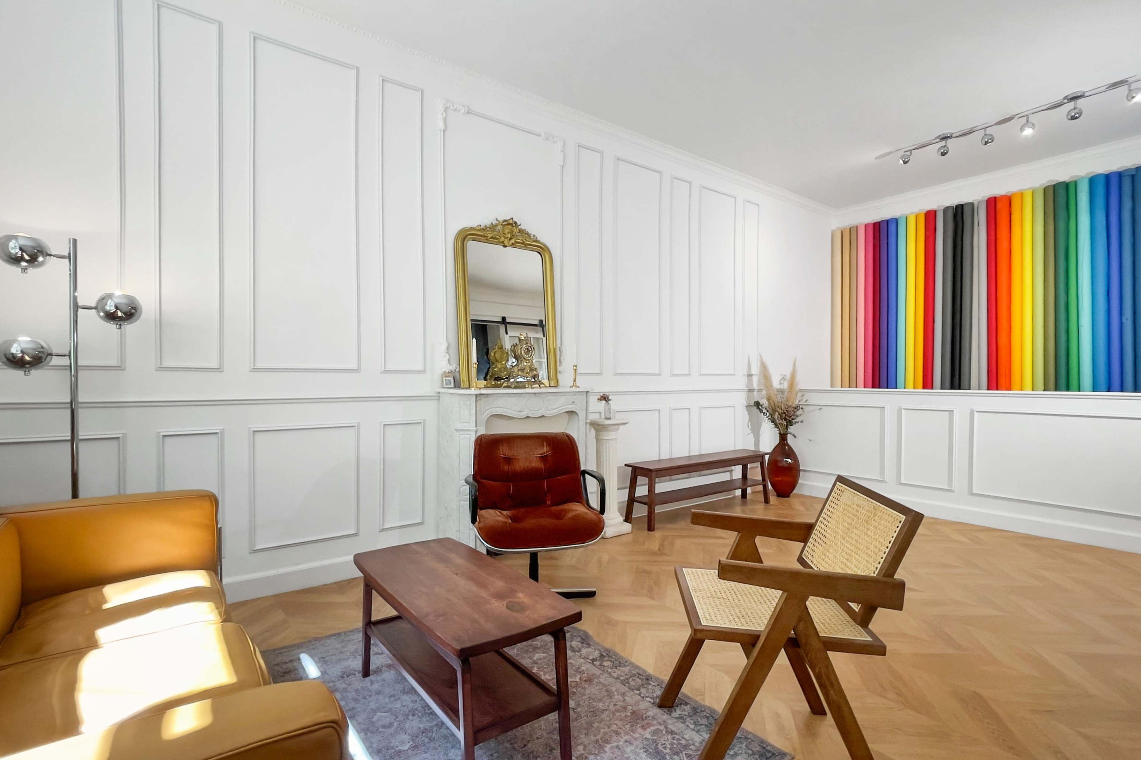 The room features a combination of a brown leather sofa, a wooden coffee table, and a colorful striped artwork on the wall.