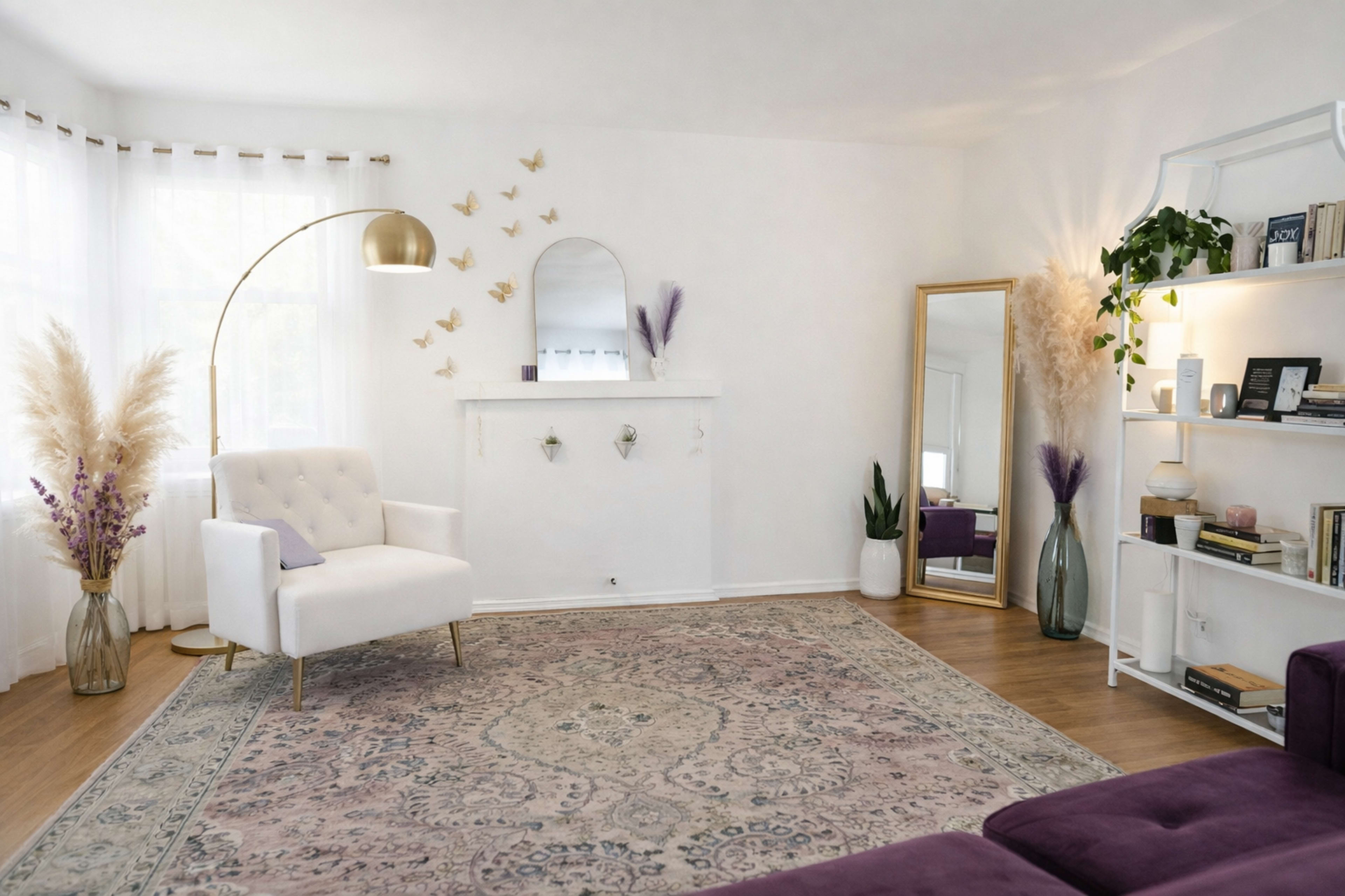 The room features a white-paneled wall with a decorative mirror, a plush white armchair, and a large area rug, complemented by plants and decorative elements on shelves.