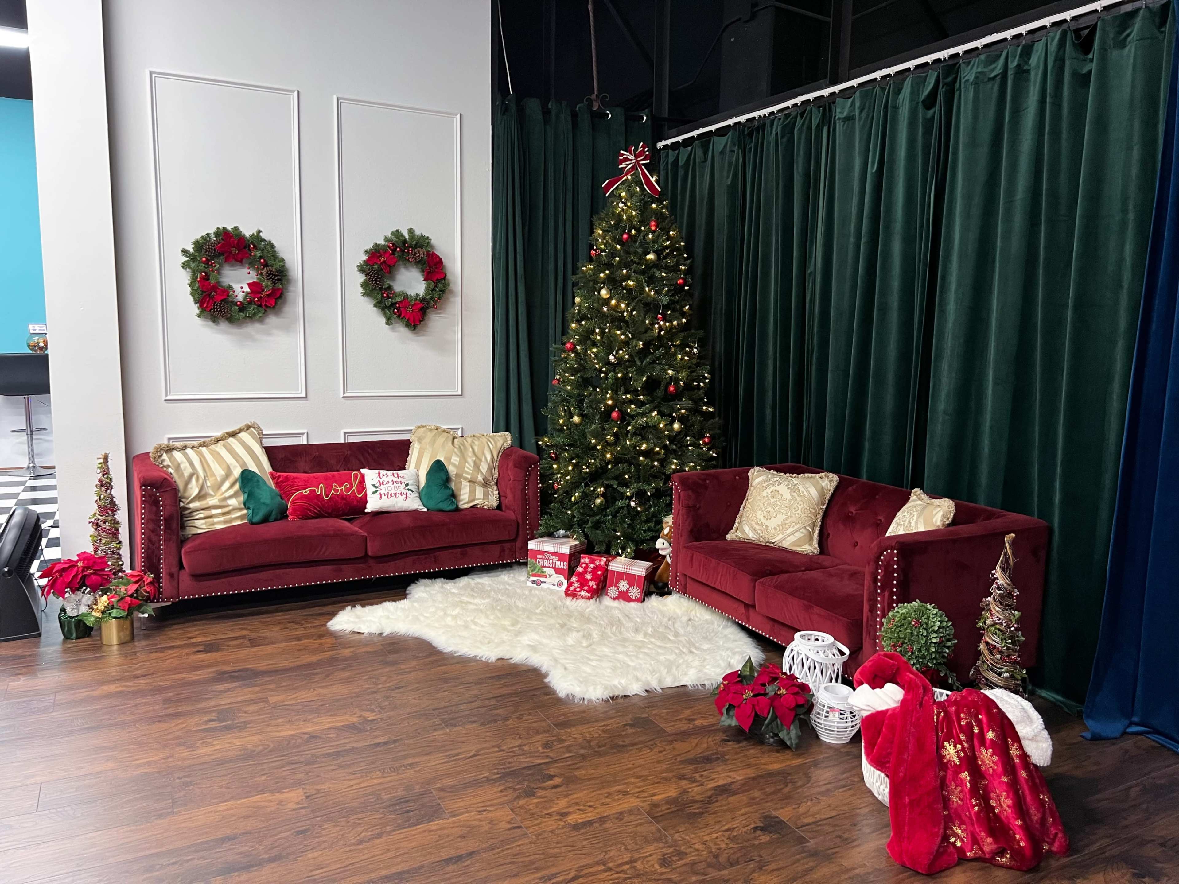 The scene features a festive holiday setup with a decorated Christmas tree, red sofas, and various seasonal decorations, including wreaths and gift boxes.
