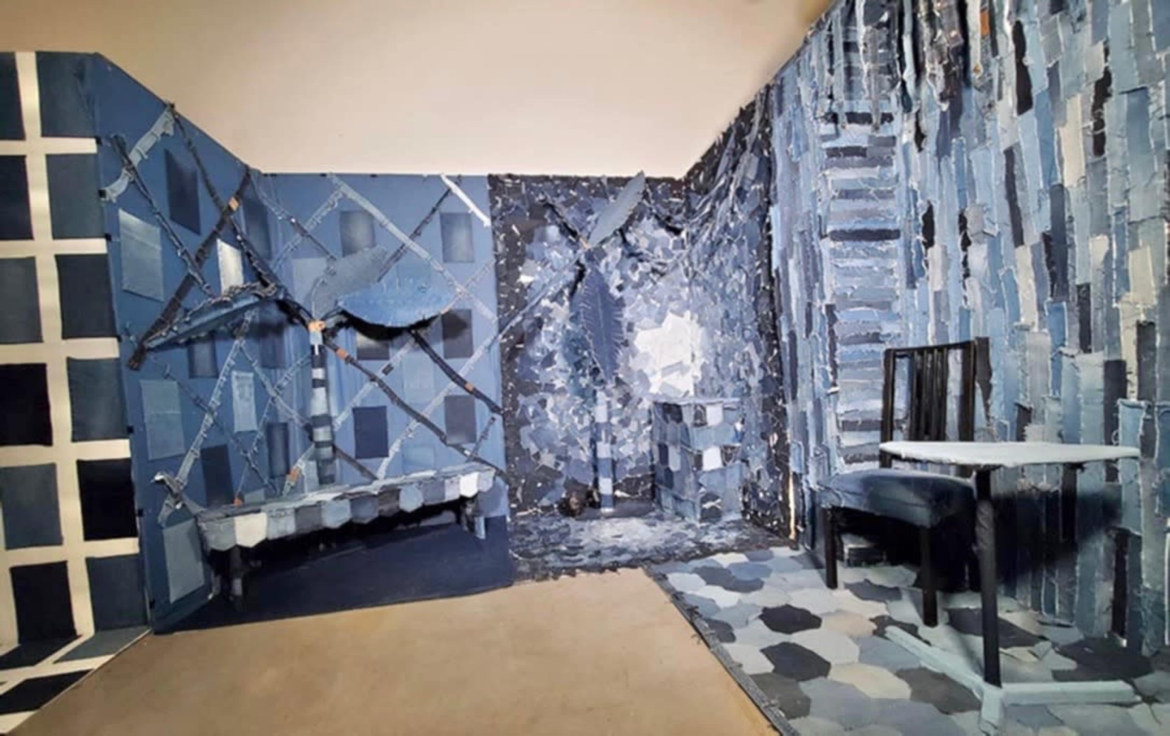 A room where the walls, floor, and furniture are covered in various shades of blue fabric, creating a cohesive monochromatic environment.