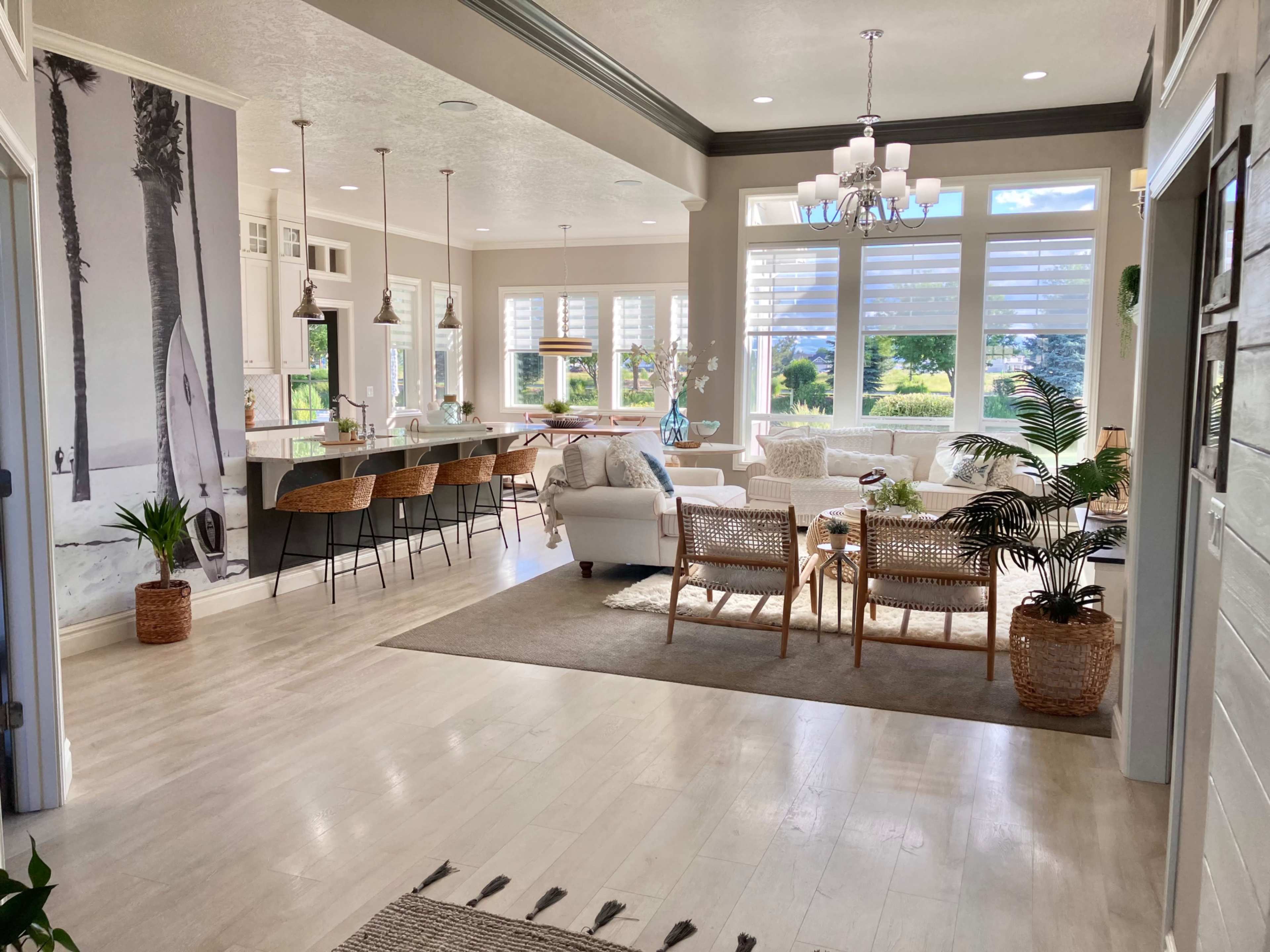 A bright, modern living space with a cozy seating area, large windows allowing natural light, and a kitchen with bar seating.