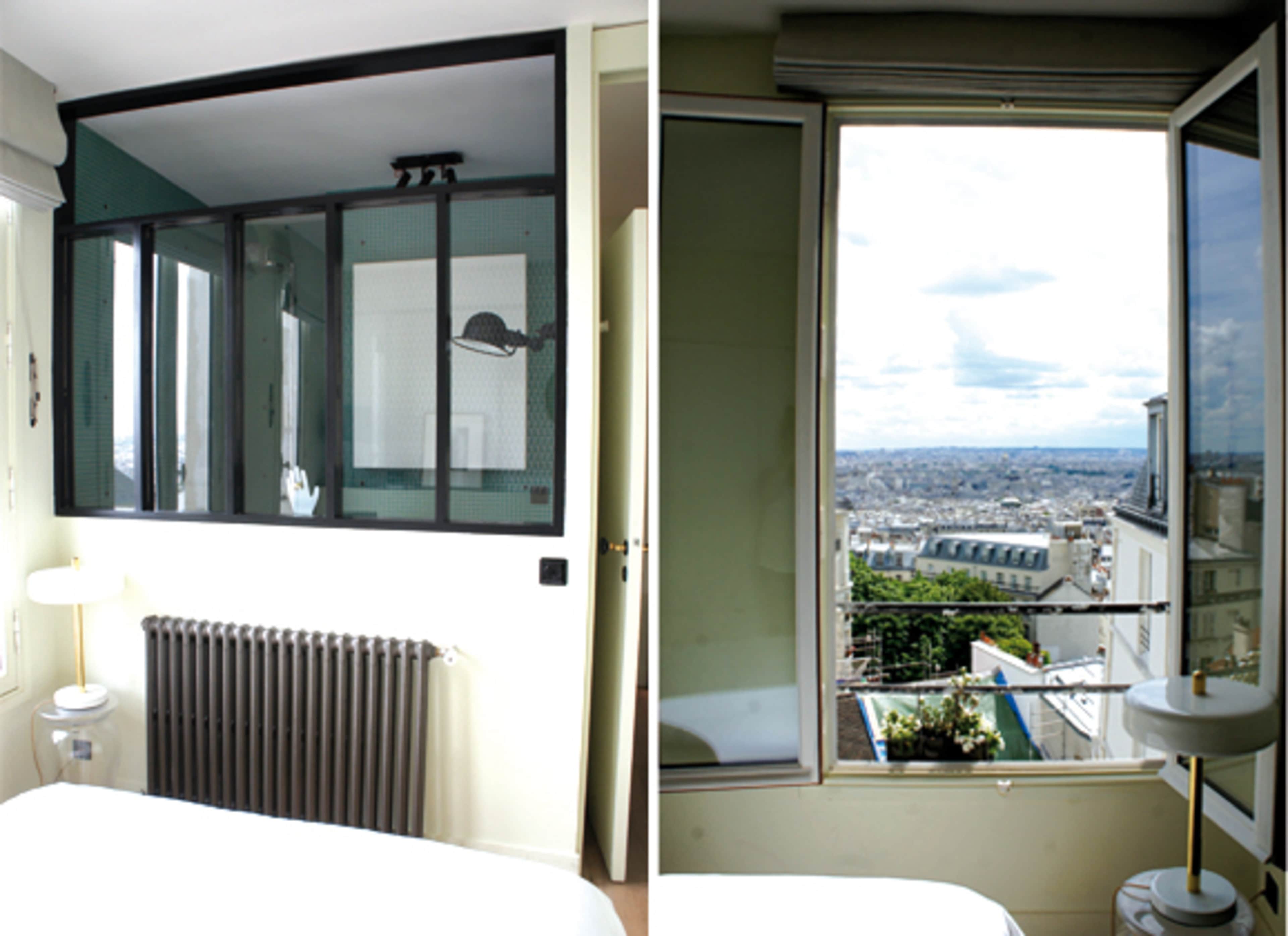 The image shows a modern bedroom with a large window offering a view of a city skyline and a radiator beneath the window.