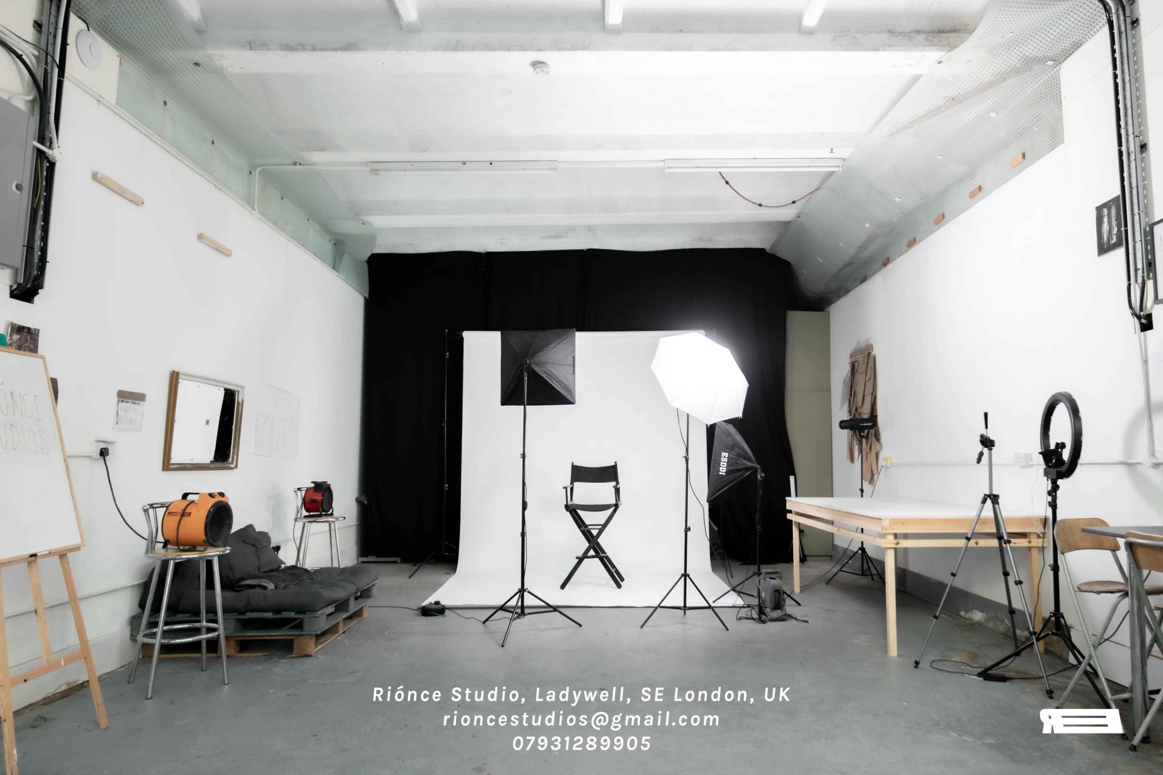 A photography studio in London features a backdrop, lighting equipment, and a director's chair.