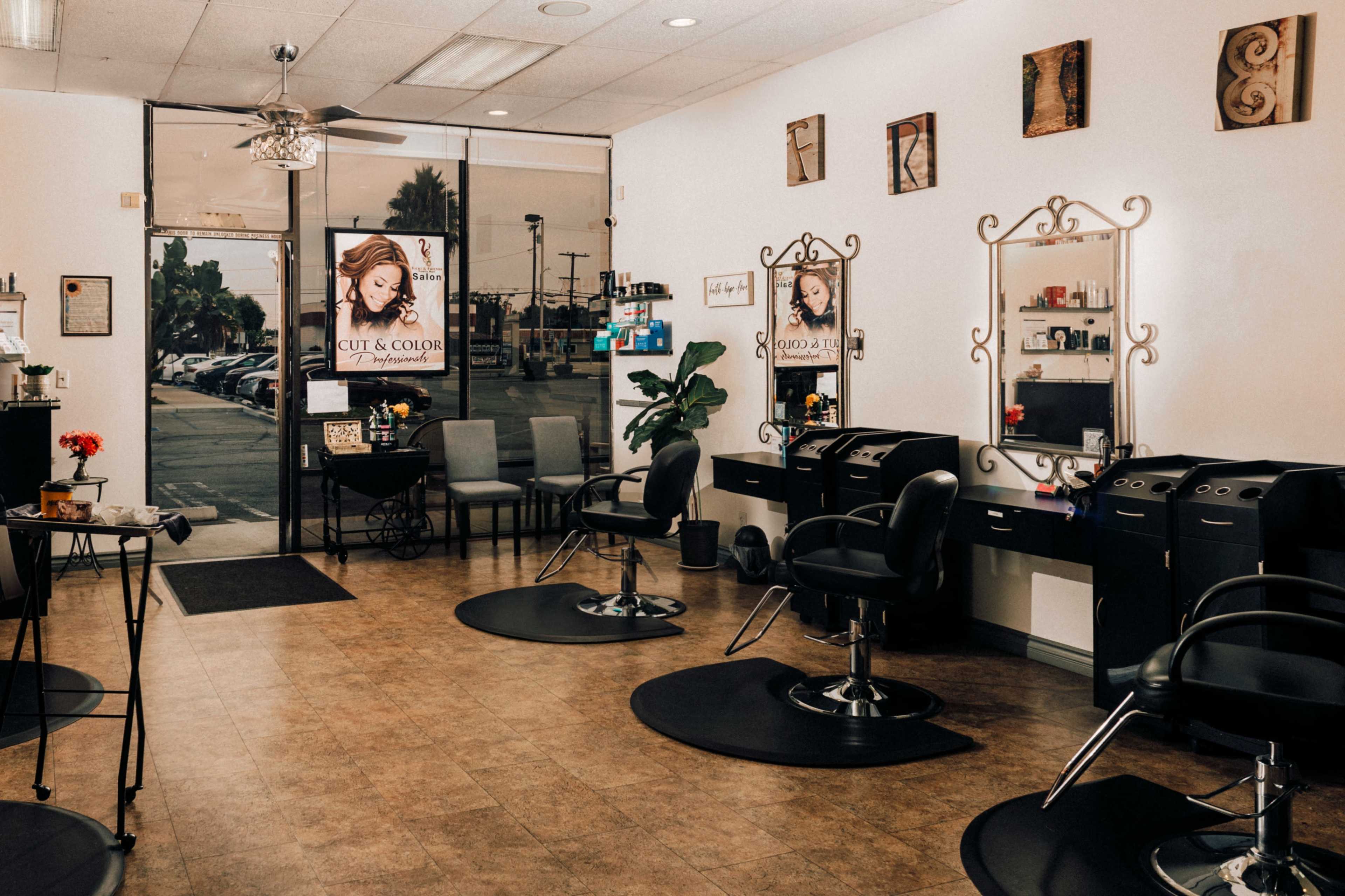 The image shows the interior of a hair salon with styling chairs, mirrors, and promotional posters on the walls.