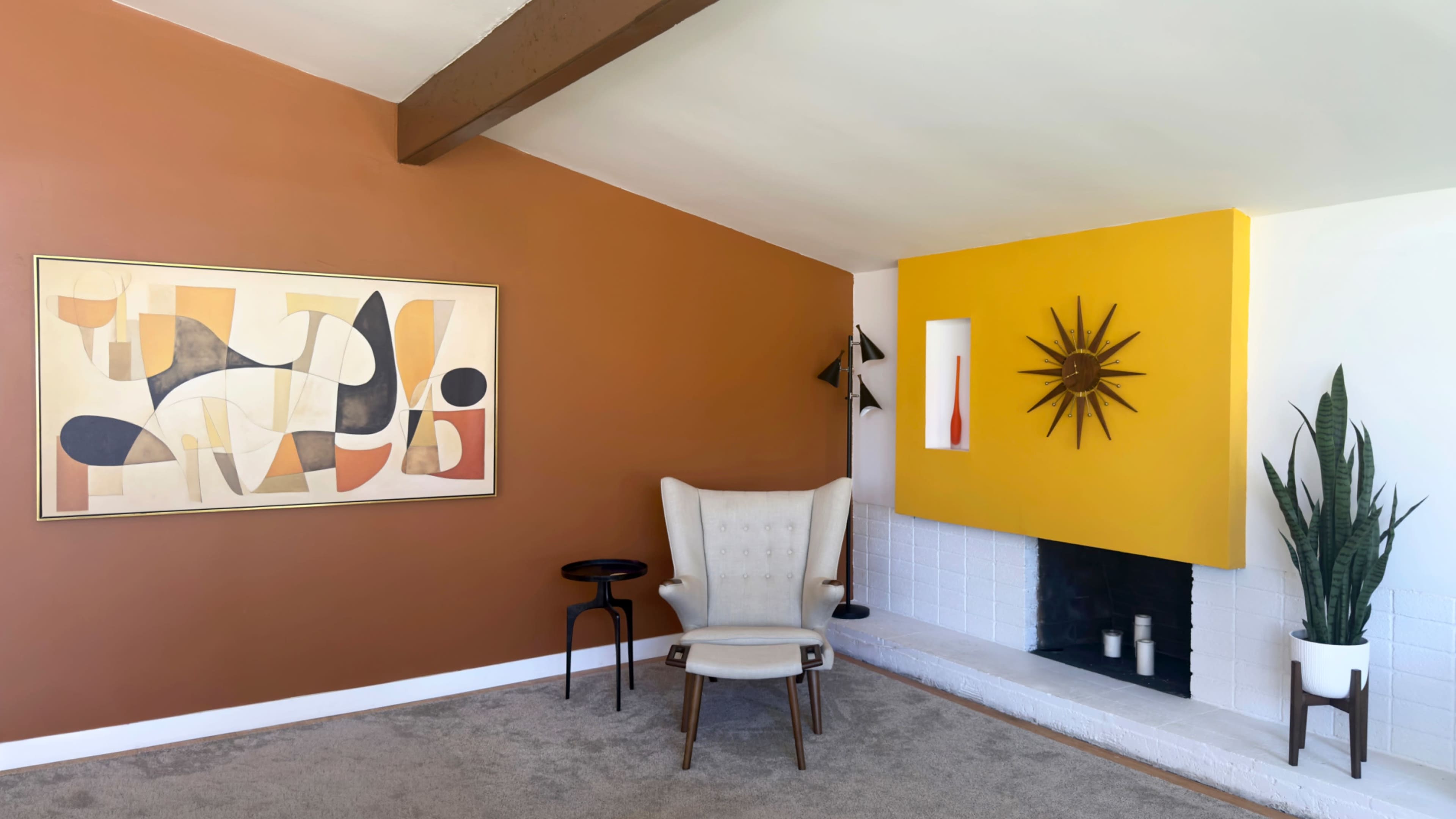 The image shows a mid-century modern living room featuring an orange and yellow color scheme, a prominent wall art piece, a white fireplace, and a large armchair.