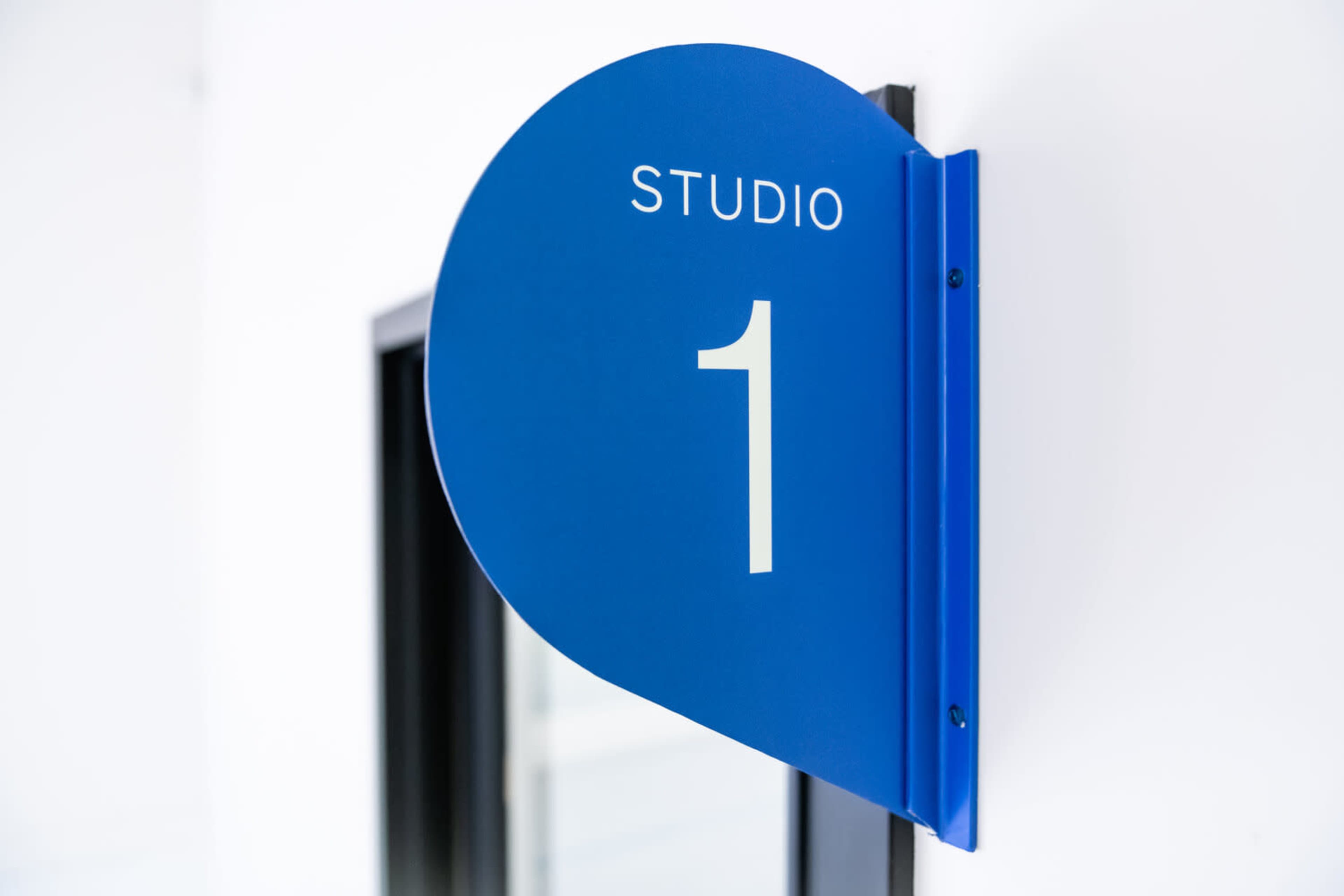 A blue sign on a wall that reads "STUDIO 1."