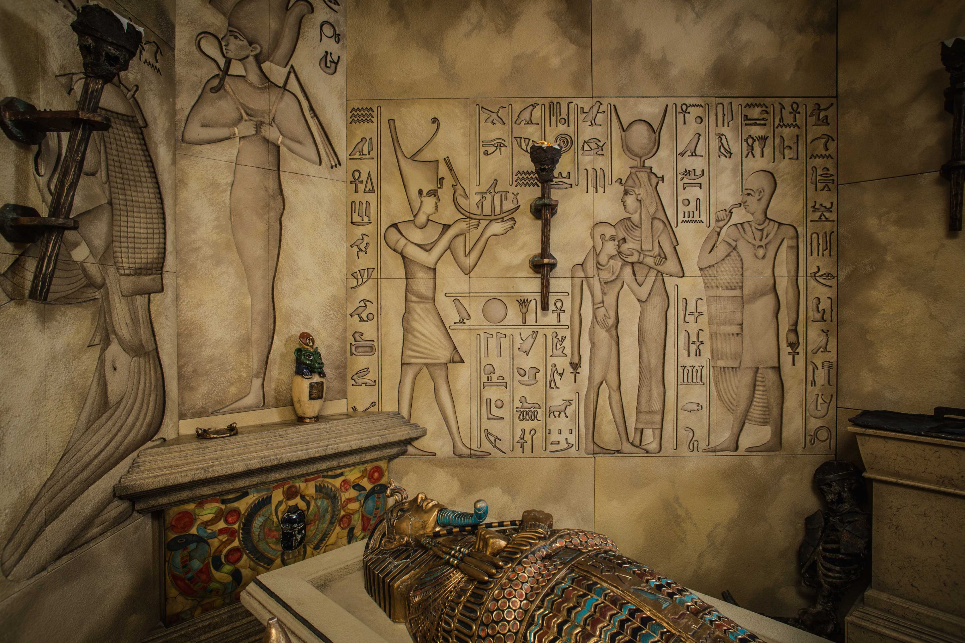 An intricately designed ancient Egyptian tomb interior featuring wall carvings, a sarcophagus, and various decorative artifacts.