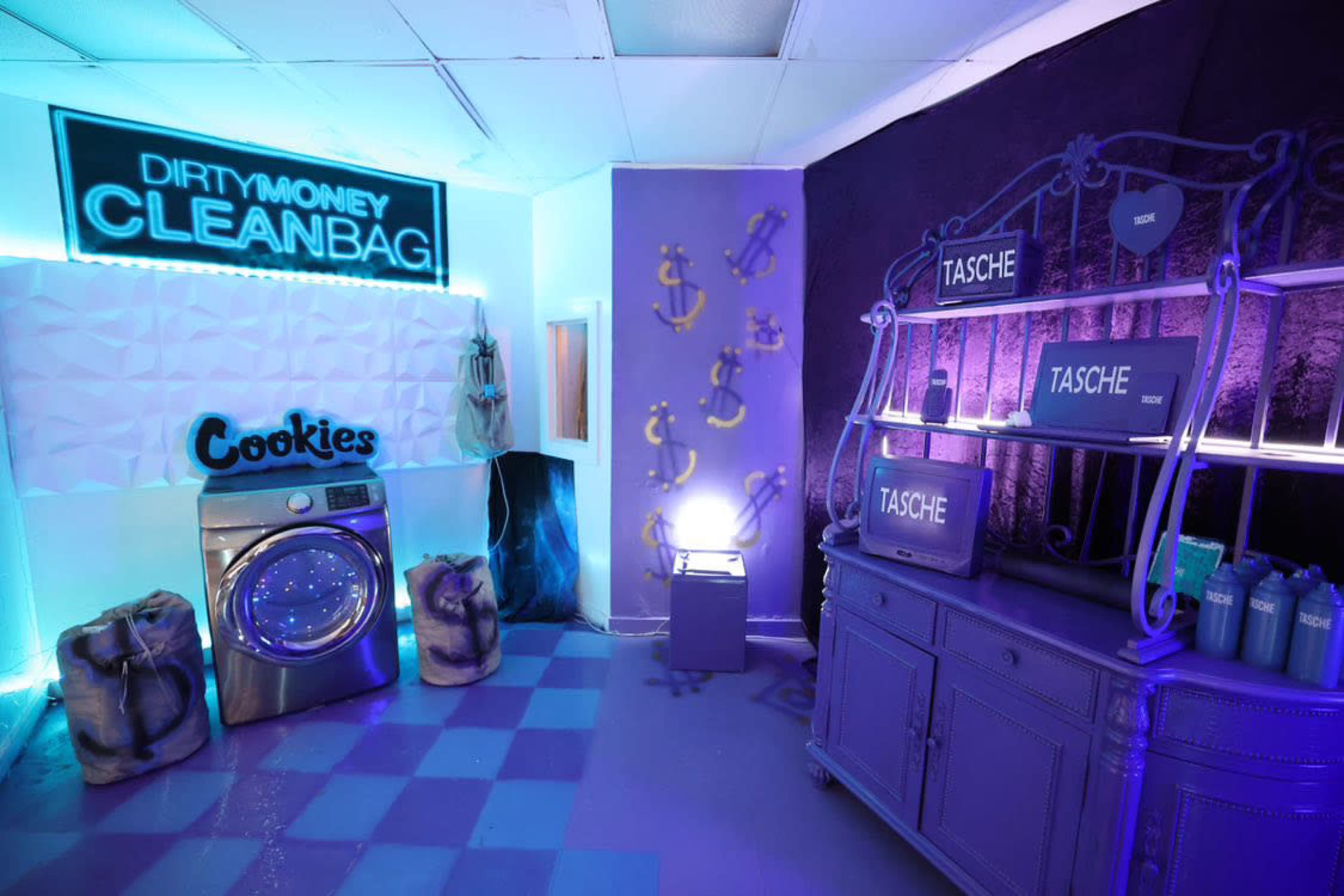 A colorful modern room featuring a laundry machine, decorative shelving with signs, and illuminated walls with a cookie-themed display.