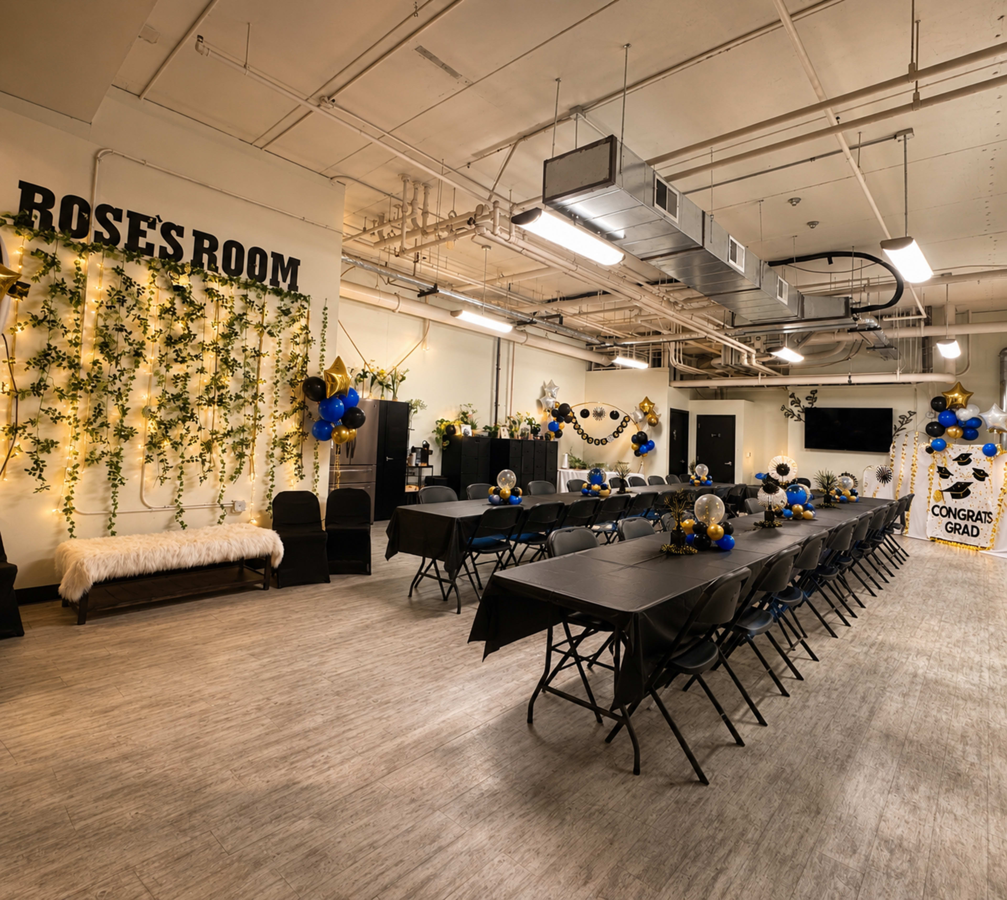 The image shows a decorated event space named "Rose's Room" with a long table set for a celebration, adorned with black tablecloths, balloons, and floral arrangements.