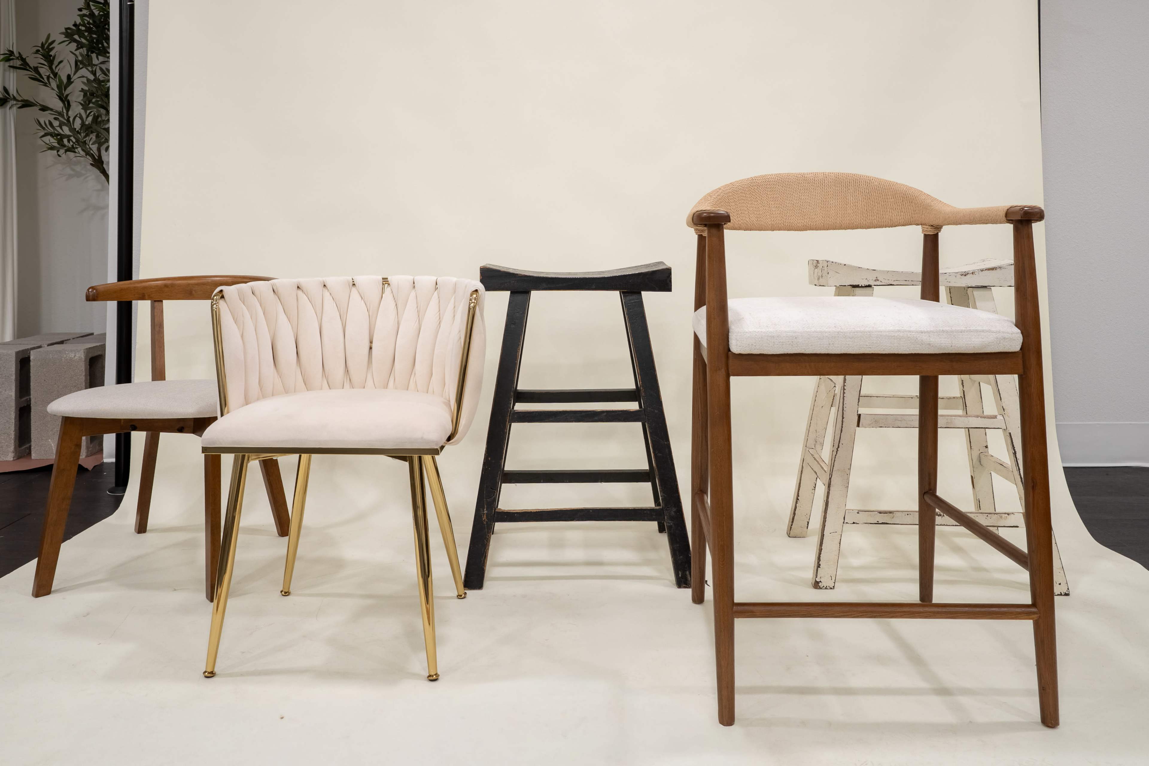 The image features a variety of five chairs, including two upholstered and three wooden designs, arranged in front of a neutral backdrop.