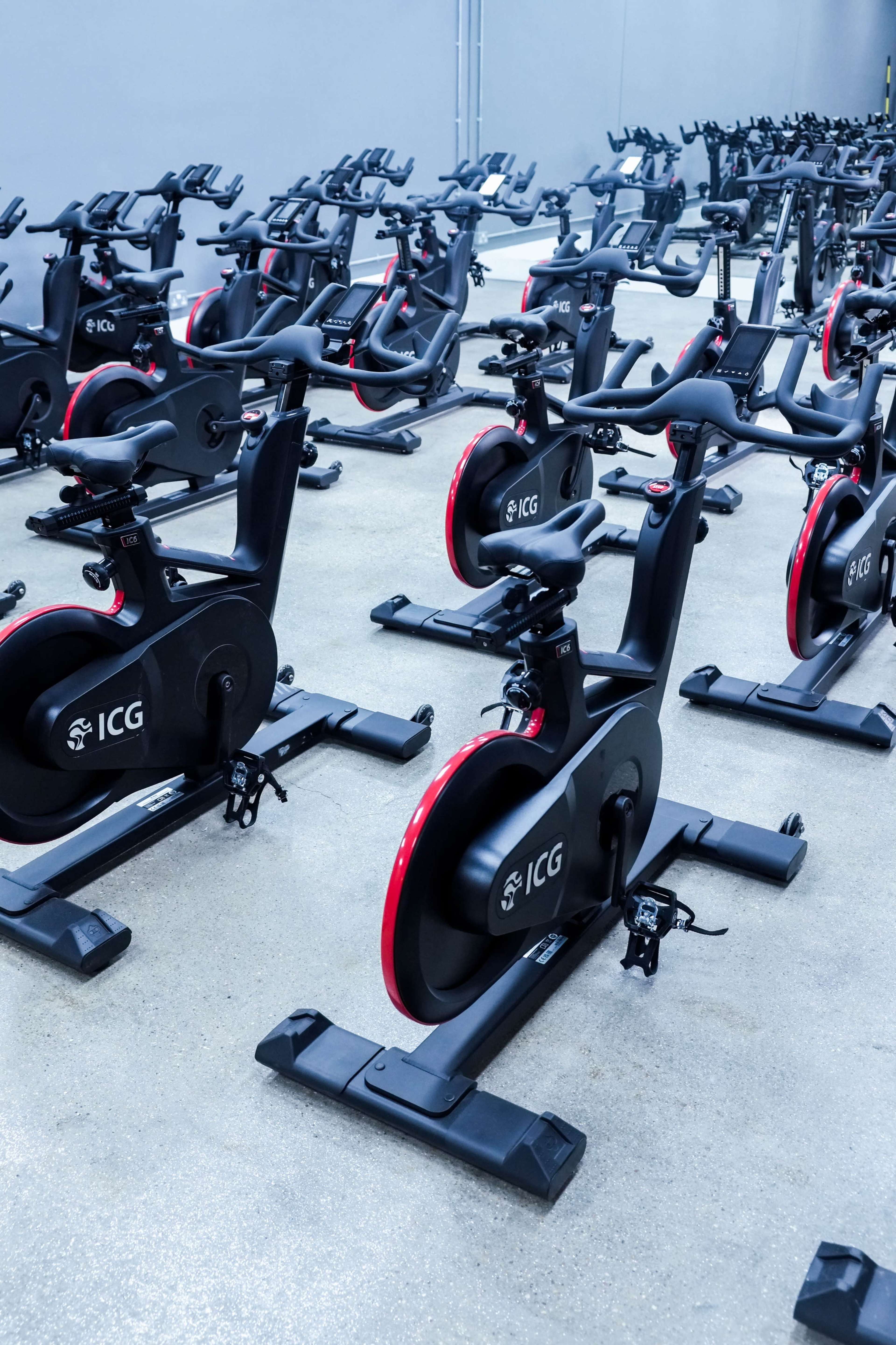 The image shows a row of stationary exercise bikes arranged in a fitness studio.