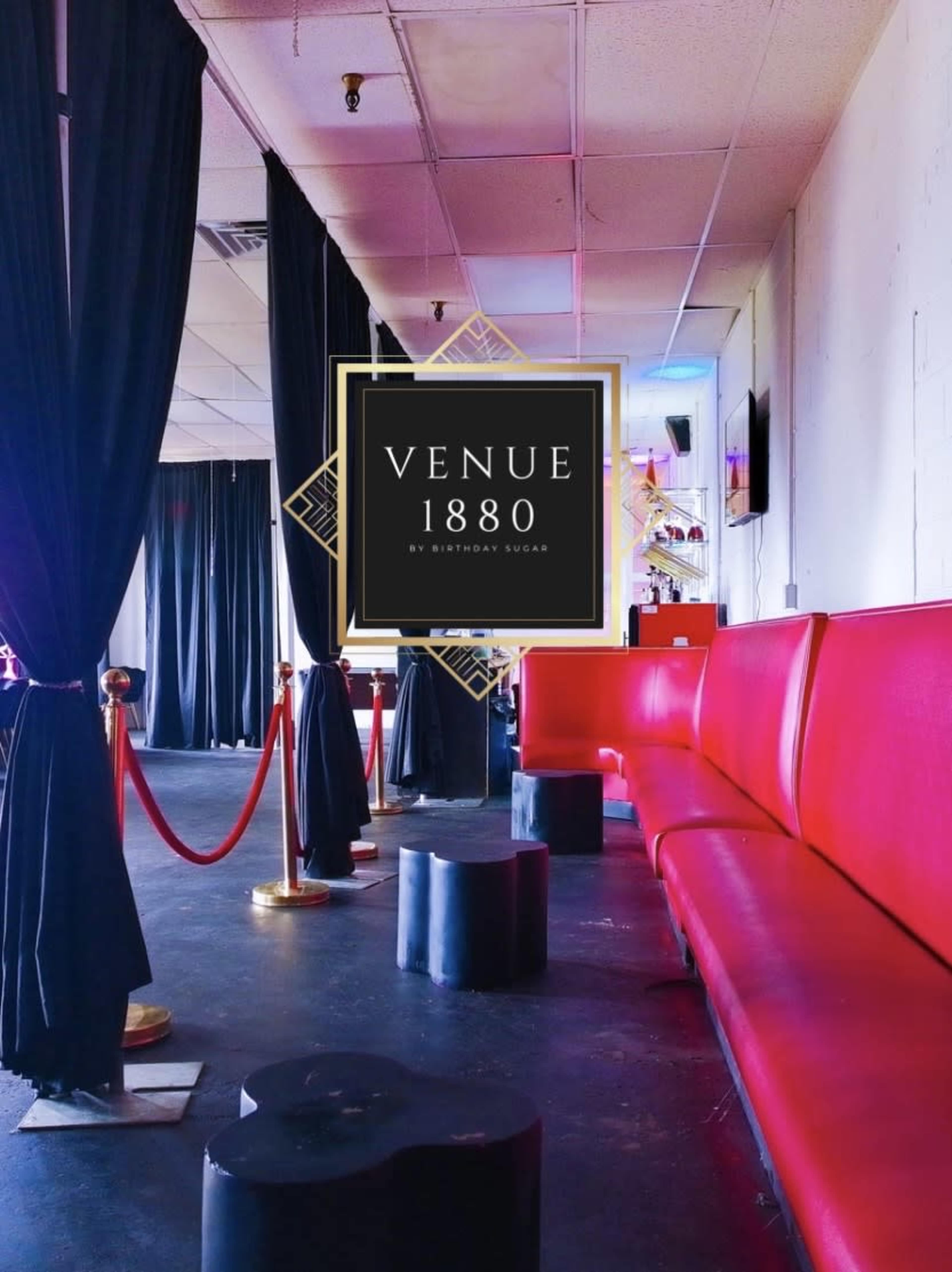 The image shows a sleek interior of a venue featuring red seating, black stools, black curtains, and a decorative sign labeled "Venue 1880."