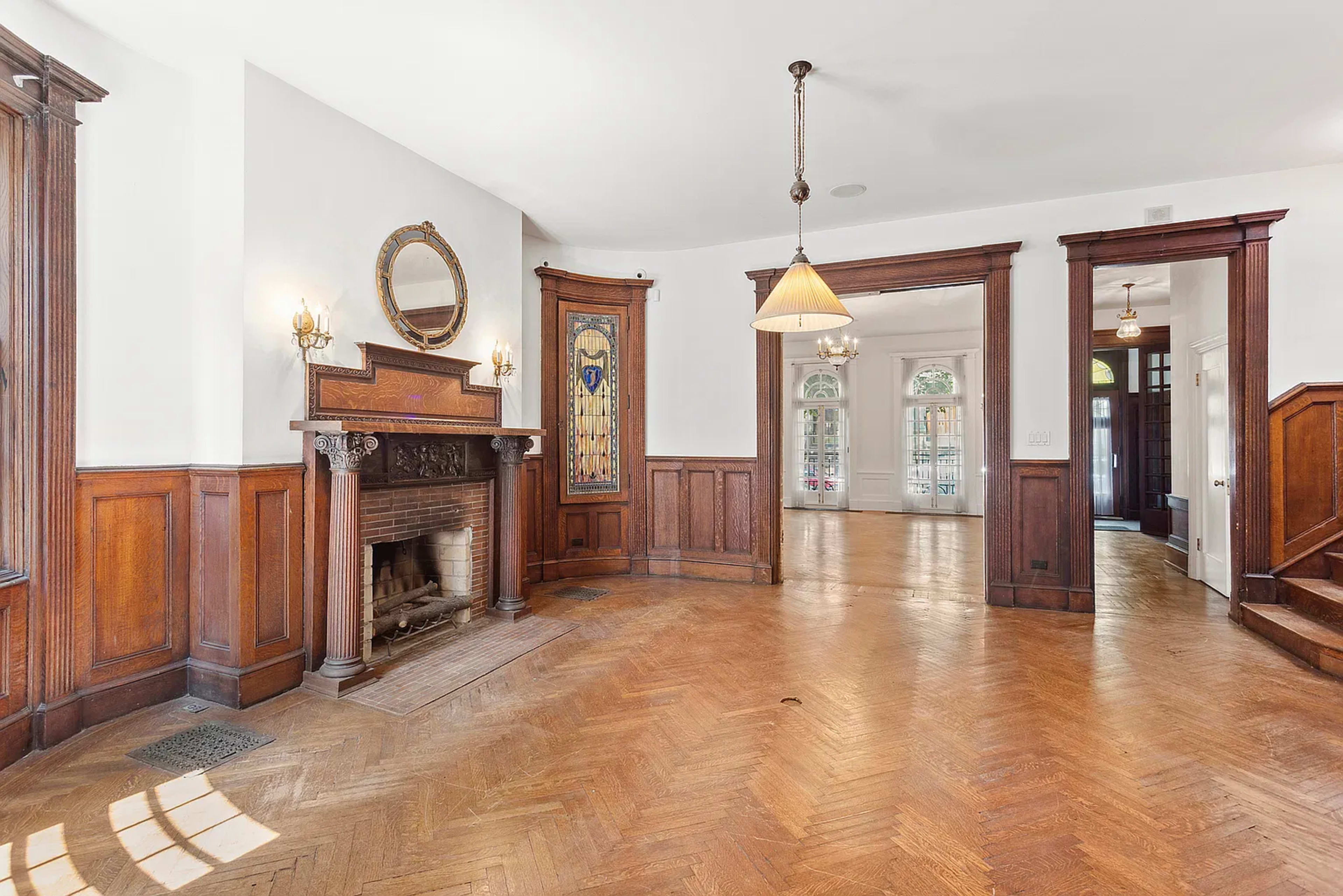 The image shows a spacious interior with wooden paneling, a fireplace, and decorative light fixtures.
