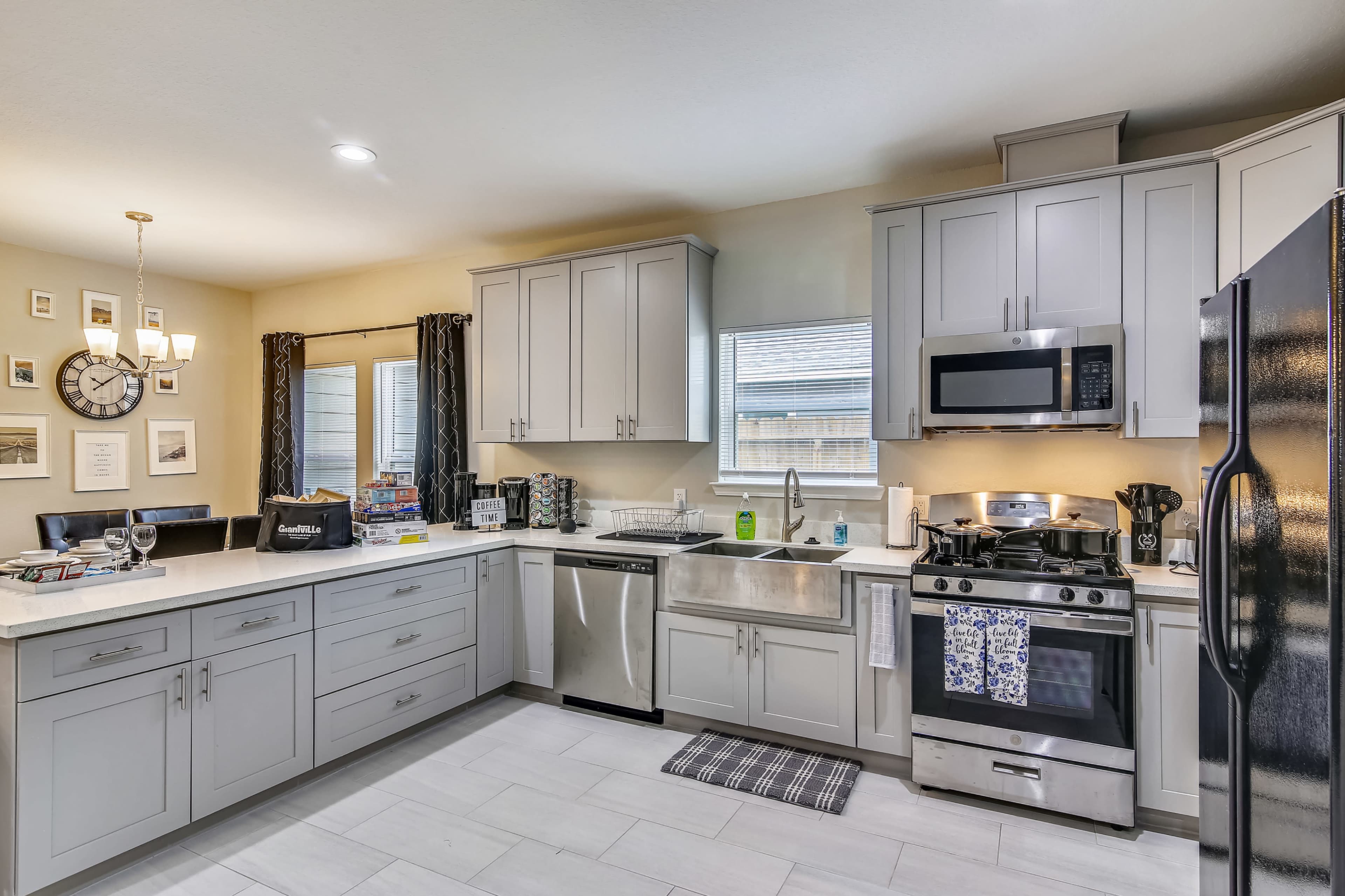 A modern kitchen featuring light gray cabinets, stainless steel appliances, and a countertop with a sink and a window.
