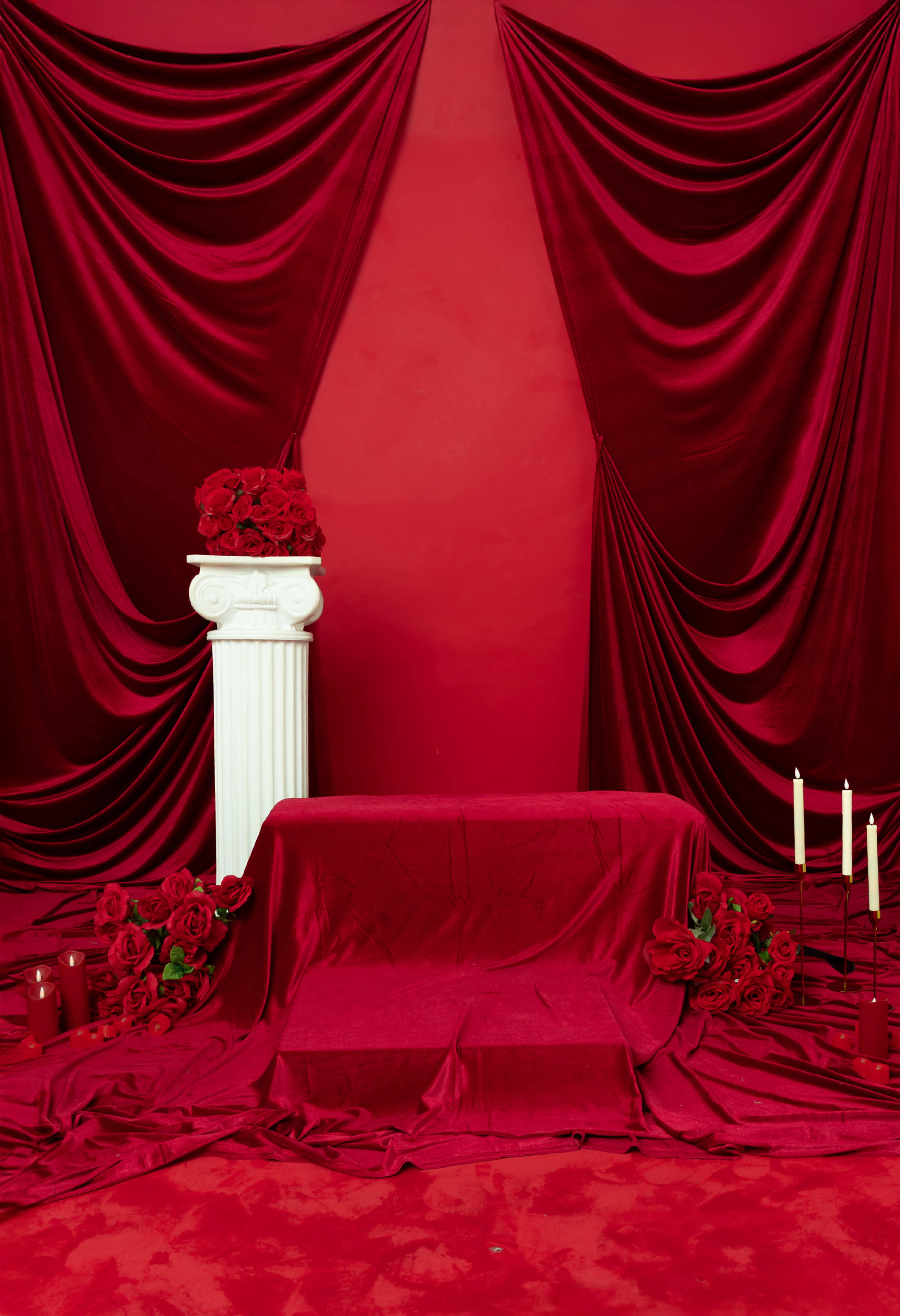 The scene features a red-themed backdrop with velvet drapery, a white column adorned with roses, and candles arranged on a similarly draped surface.