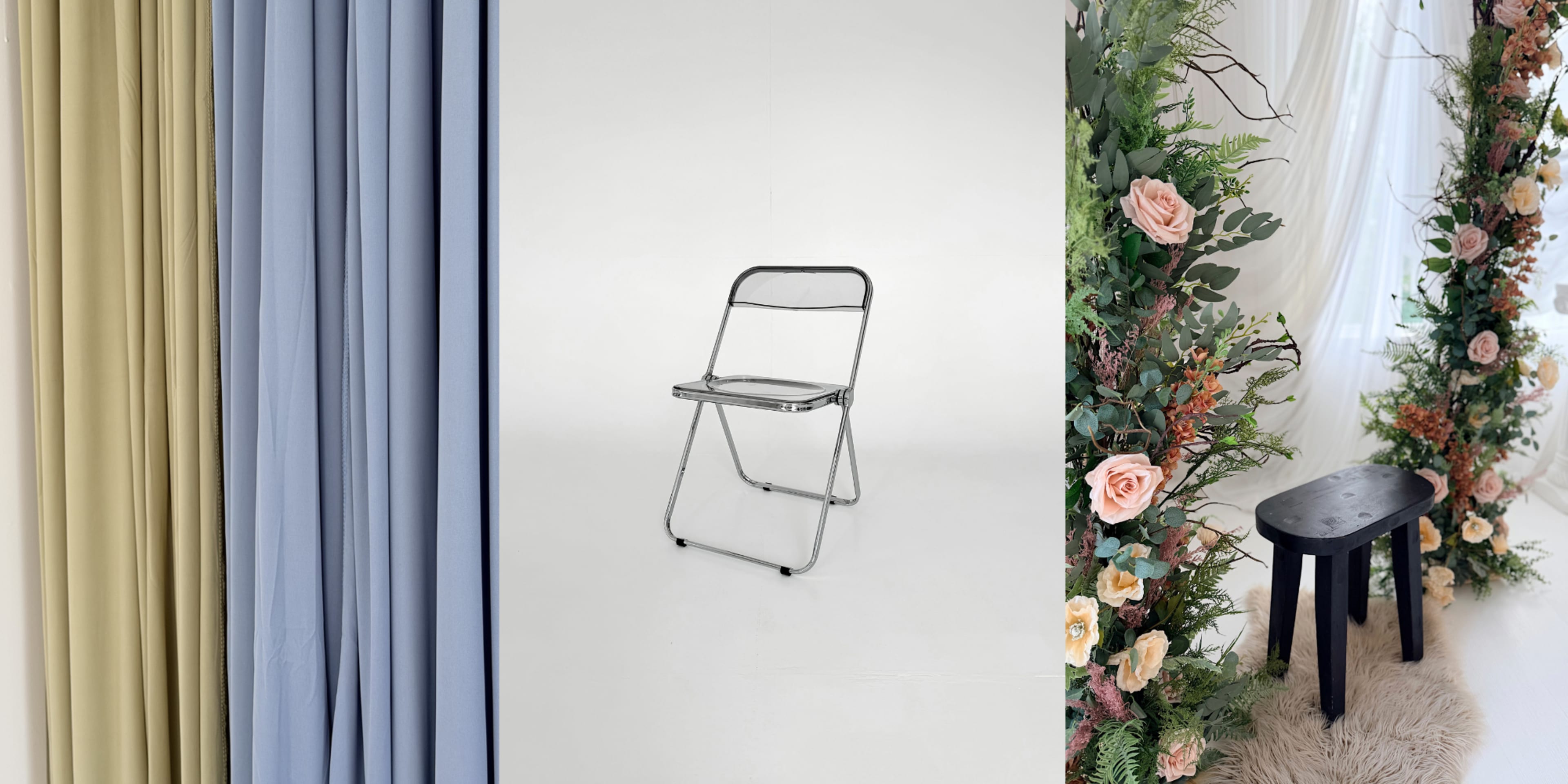 The image shows a series of draped fabrics in various colors, a metal folding chair in a plain setting, and a floral arrangement with roses beside a small black stool.