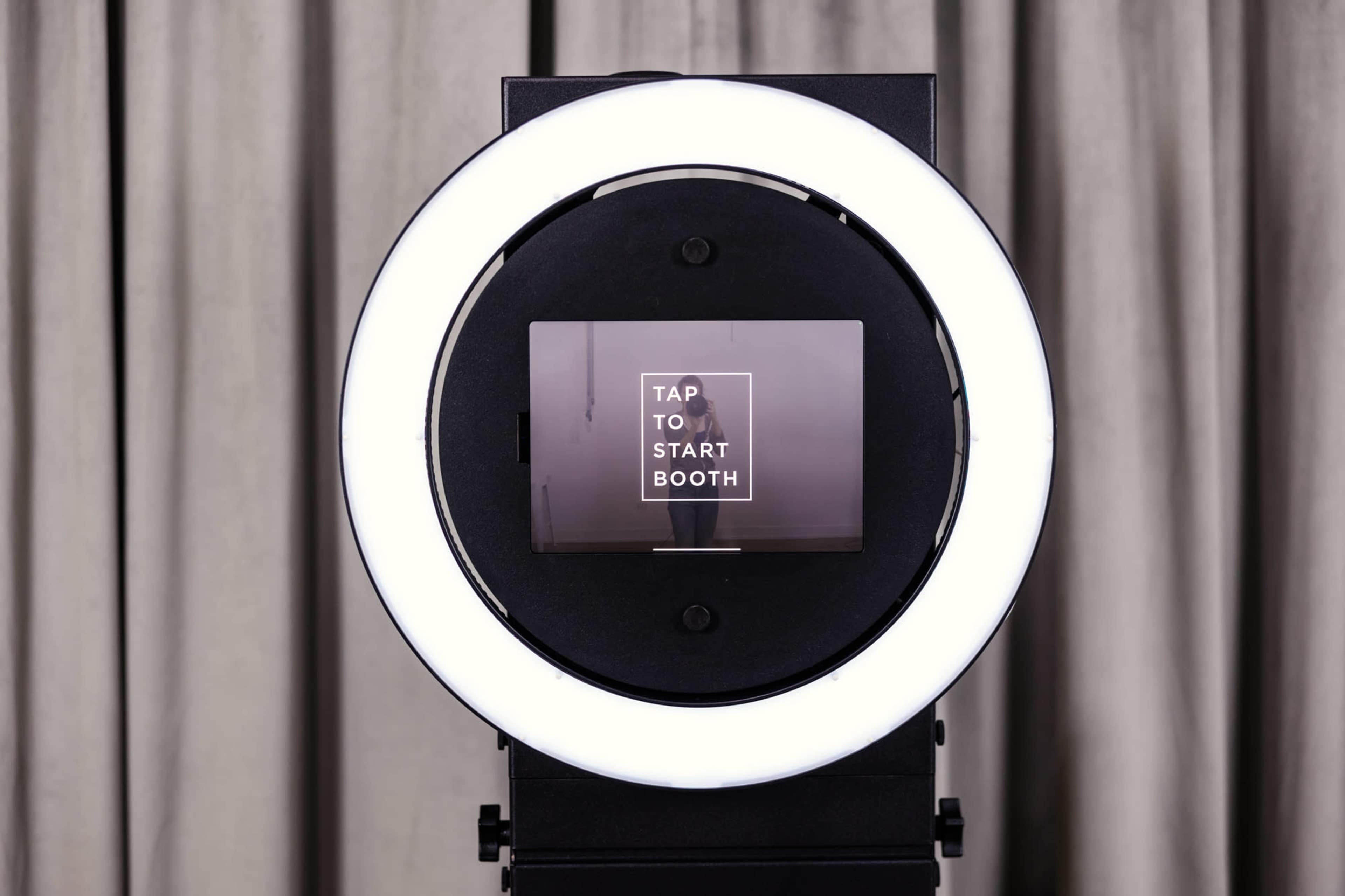A circular light surrounding a screen displays the message "TAP TO START BOOTH."