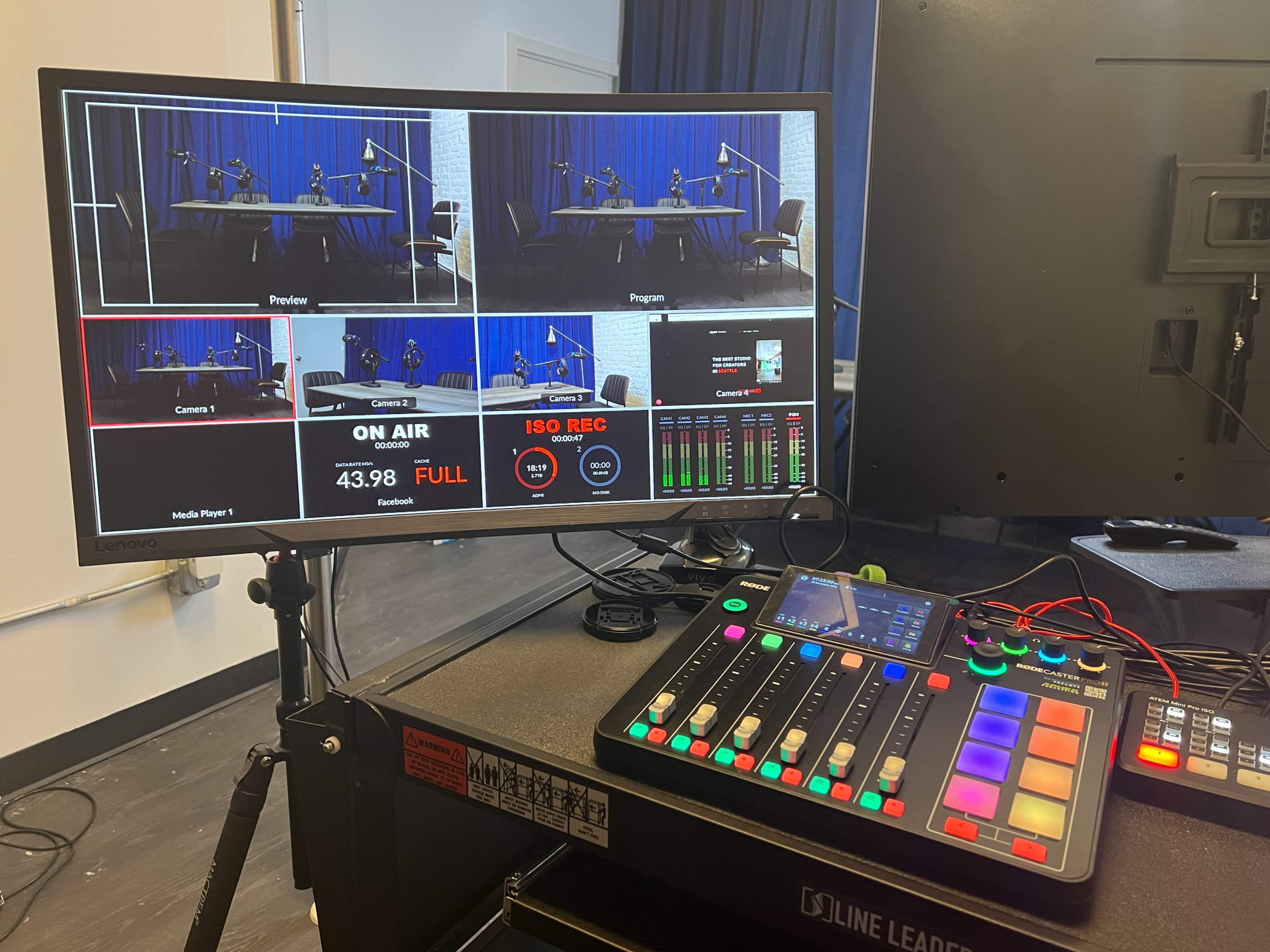 A video production monitor displaying multiple camera angles and a broadcasting control panel with various buttons and indicators.