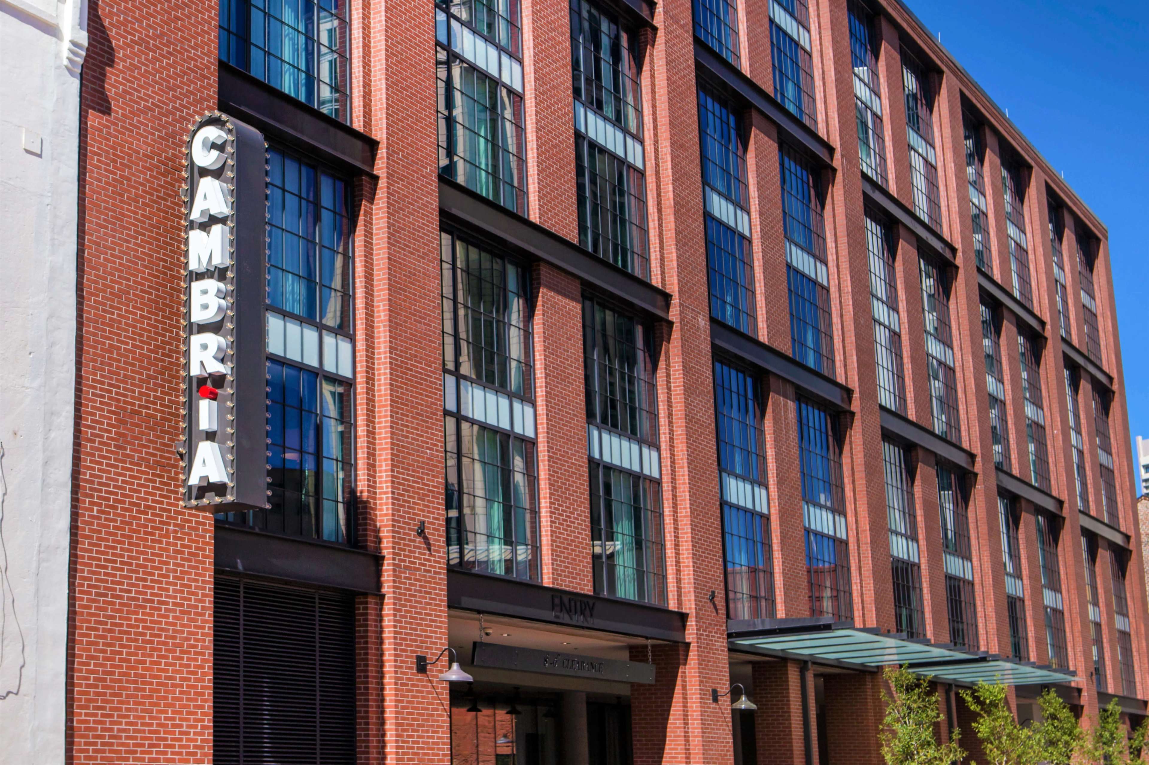 The image shows a brick building with large windows and a sign reading "CAMBRIA" on the side.