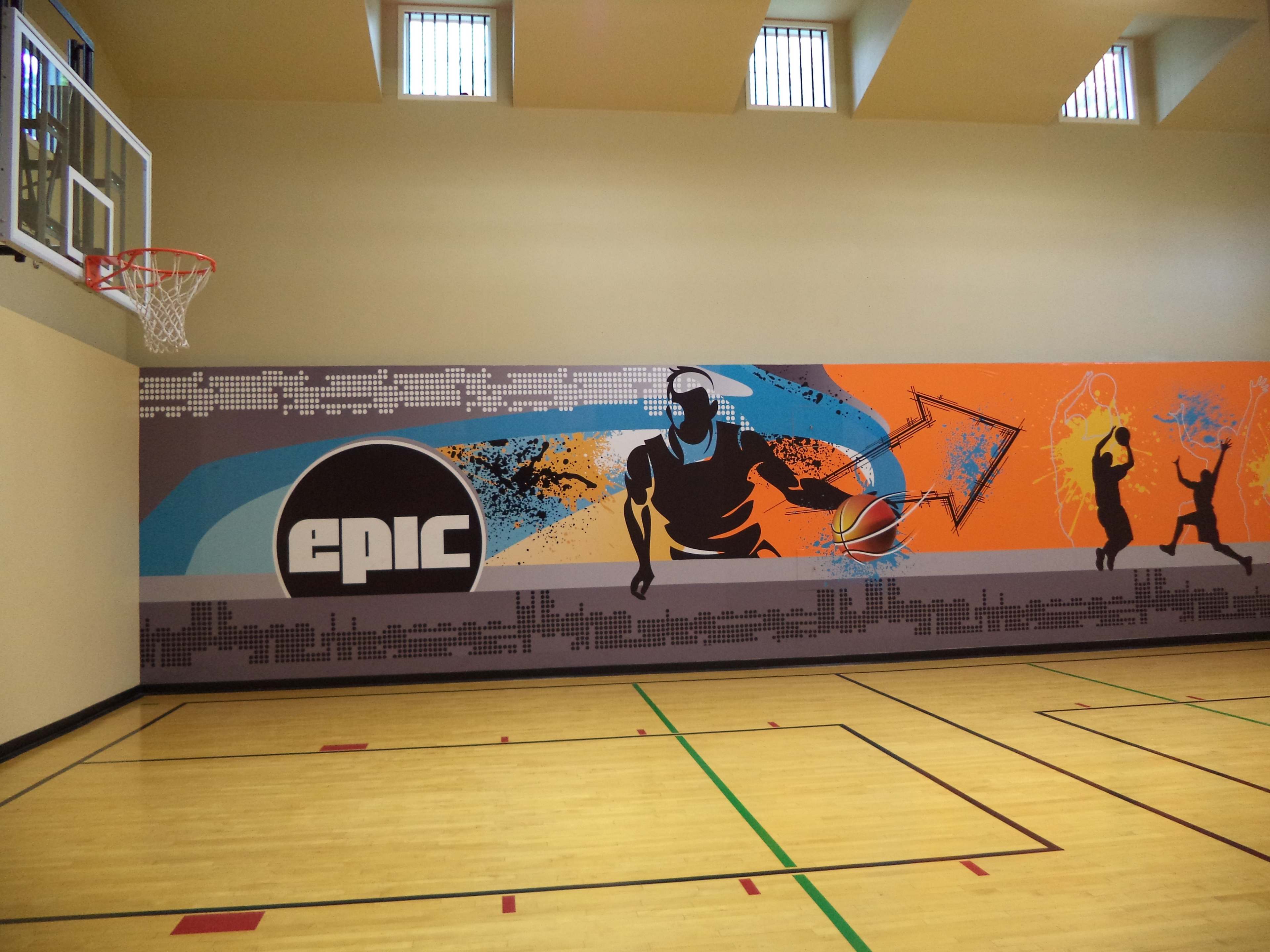 The image shows a basketball court with a colorful mural featuring stylized figures playing basketball on one wall.