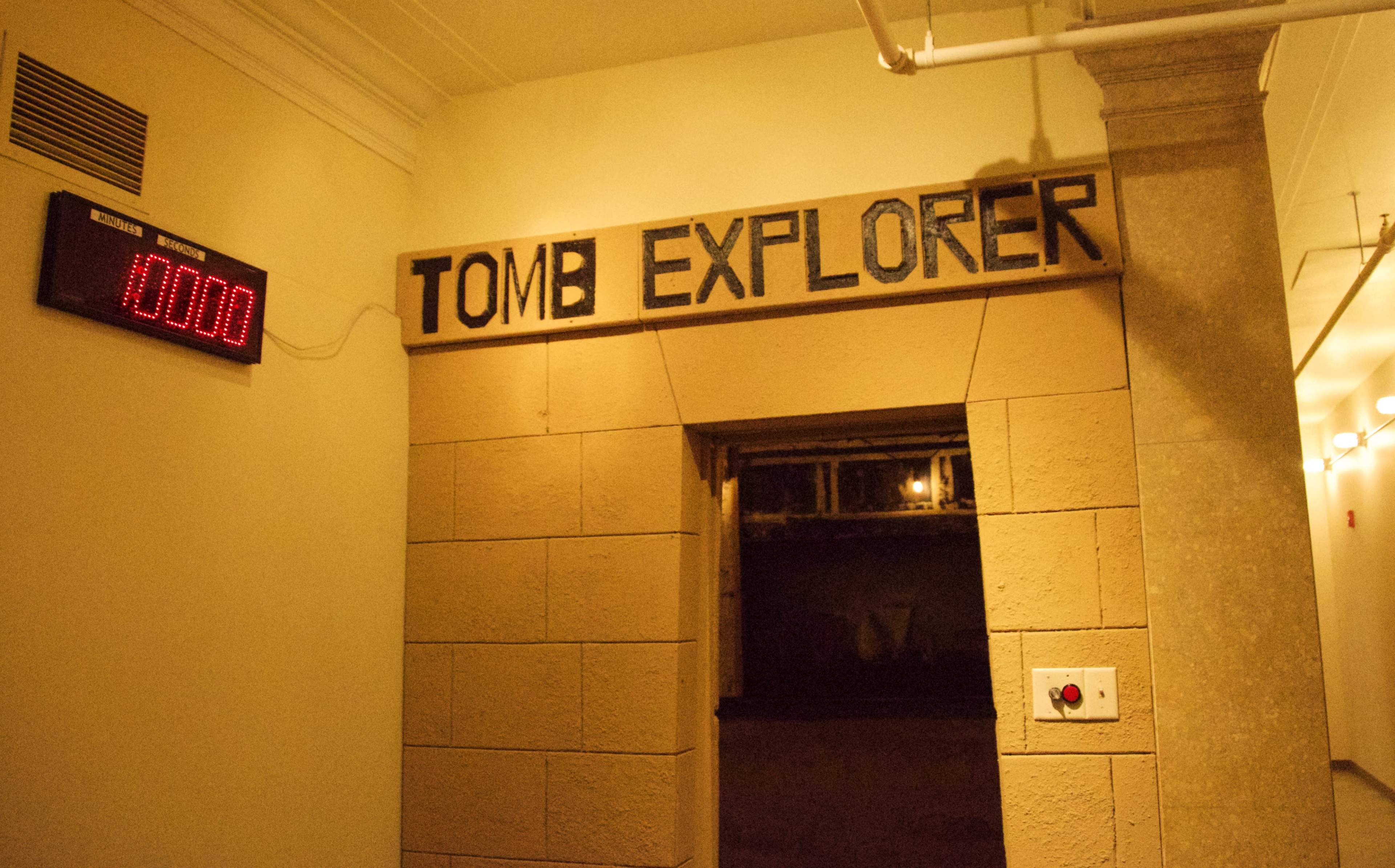 An entrance to a room labeled "TOMB EXPLORER," accompanied by a digital display showing the number 10000 on the wall.