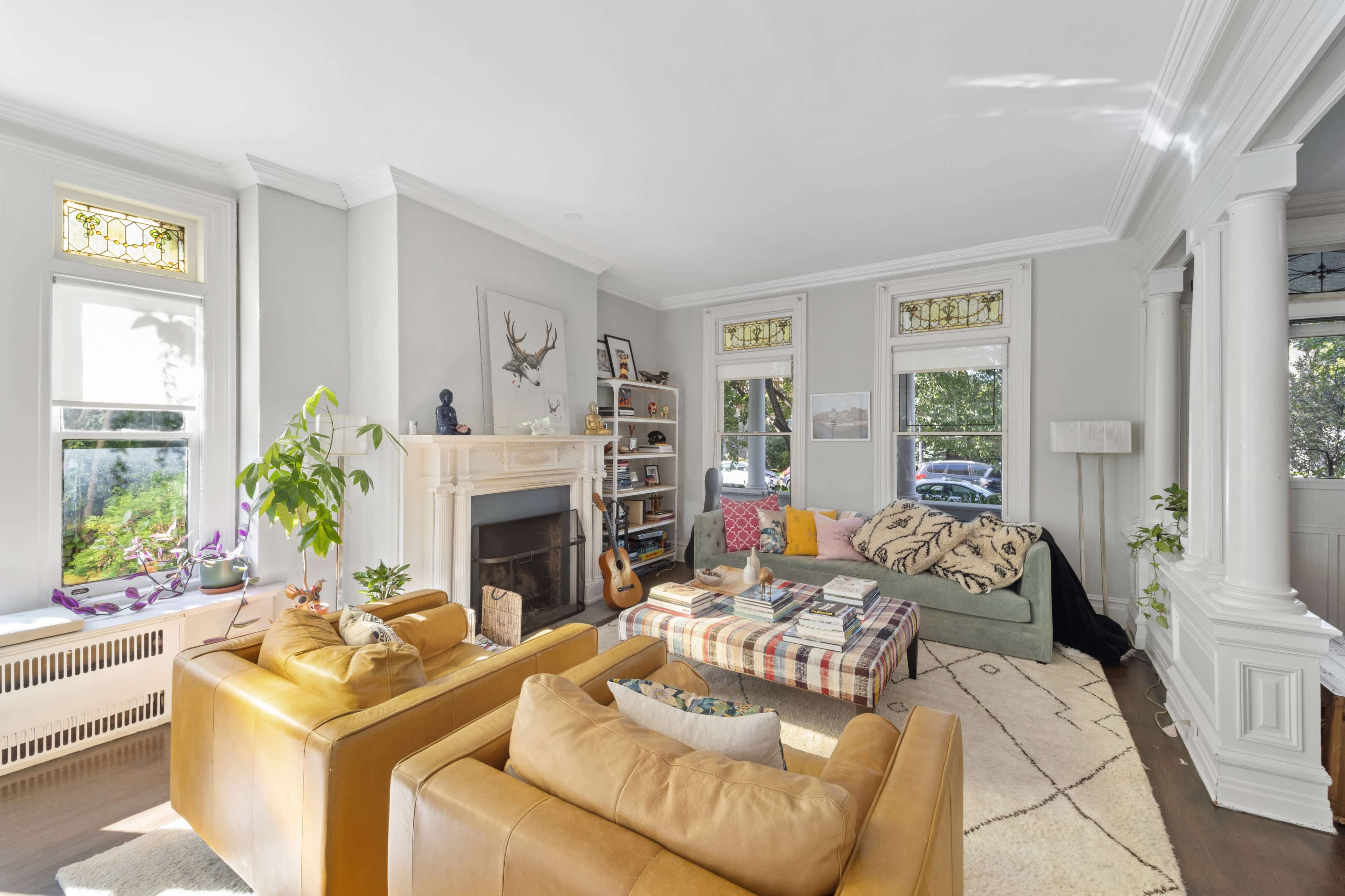 The living room features a fireplace, a large window, and seating arranged around a coffee table.