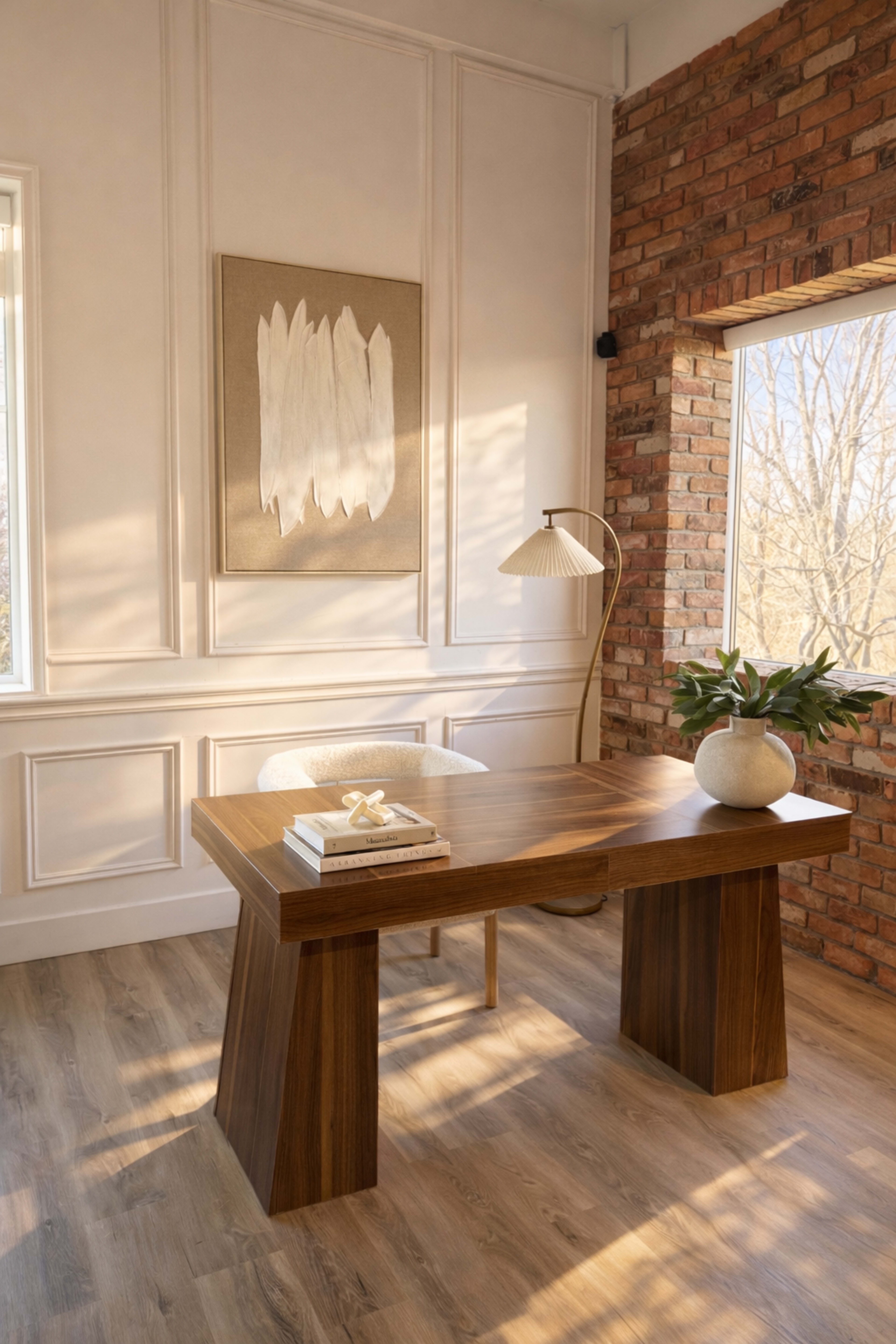 The image shows a modern office space with a wooden desk, a decorative lamp, and a window exposing natural light.