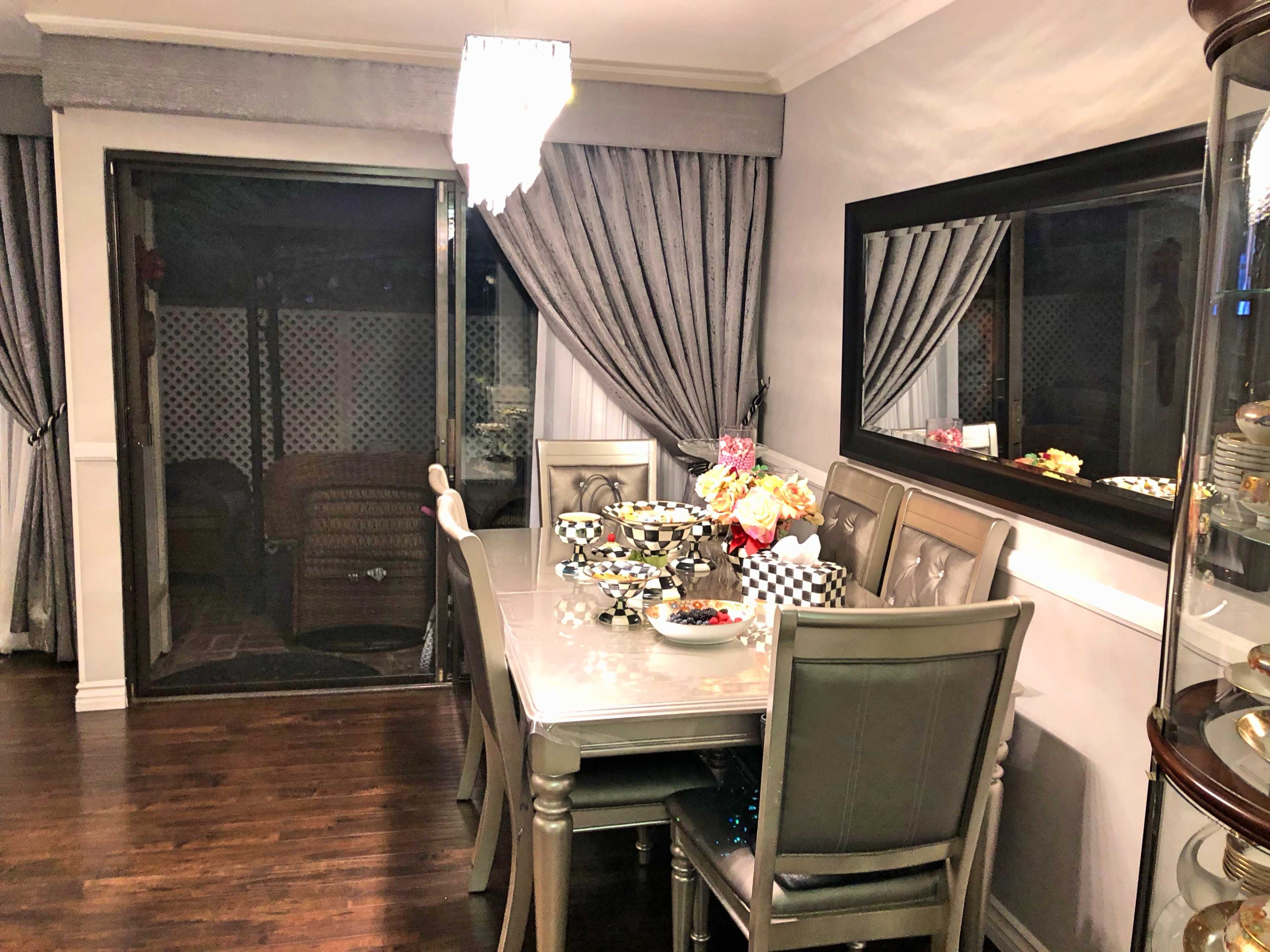 A dining area with a table set for a meal, surrounded by chairs, and featuring decorative items on the table.