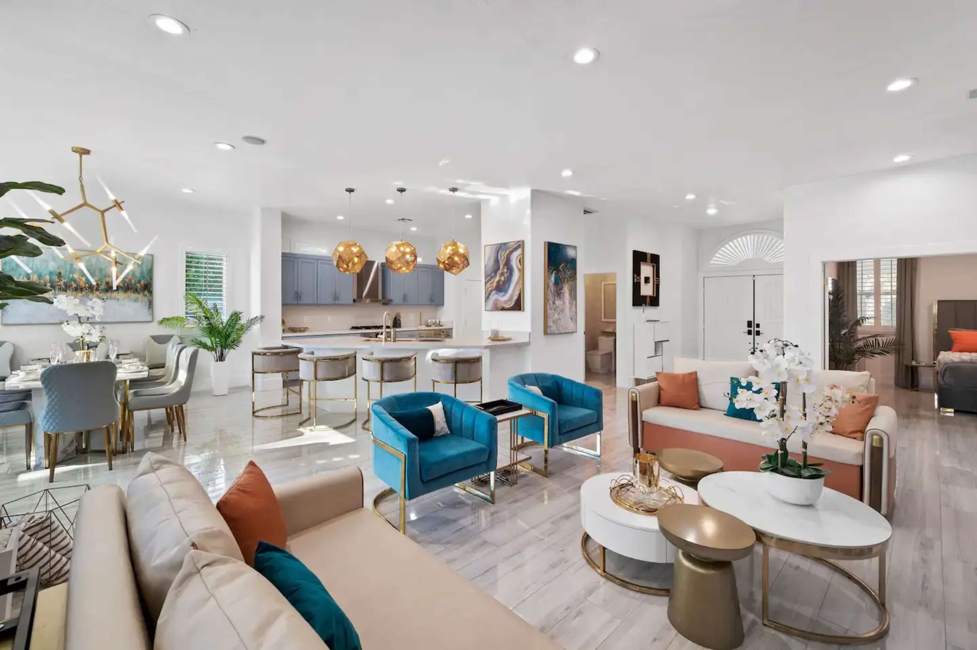A modern open-concept living and dining area featuring a color scheme of light tones, stylish furniture, and contemporary light fixtures.