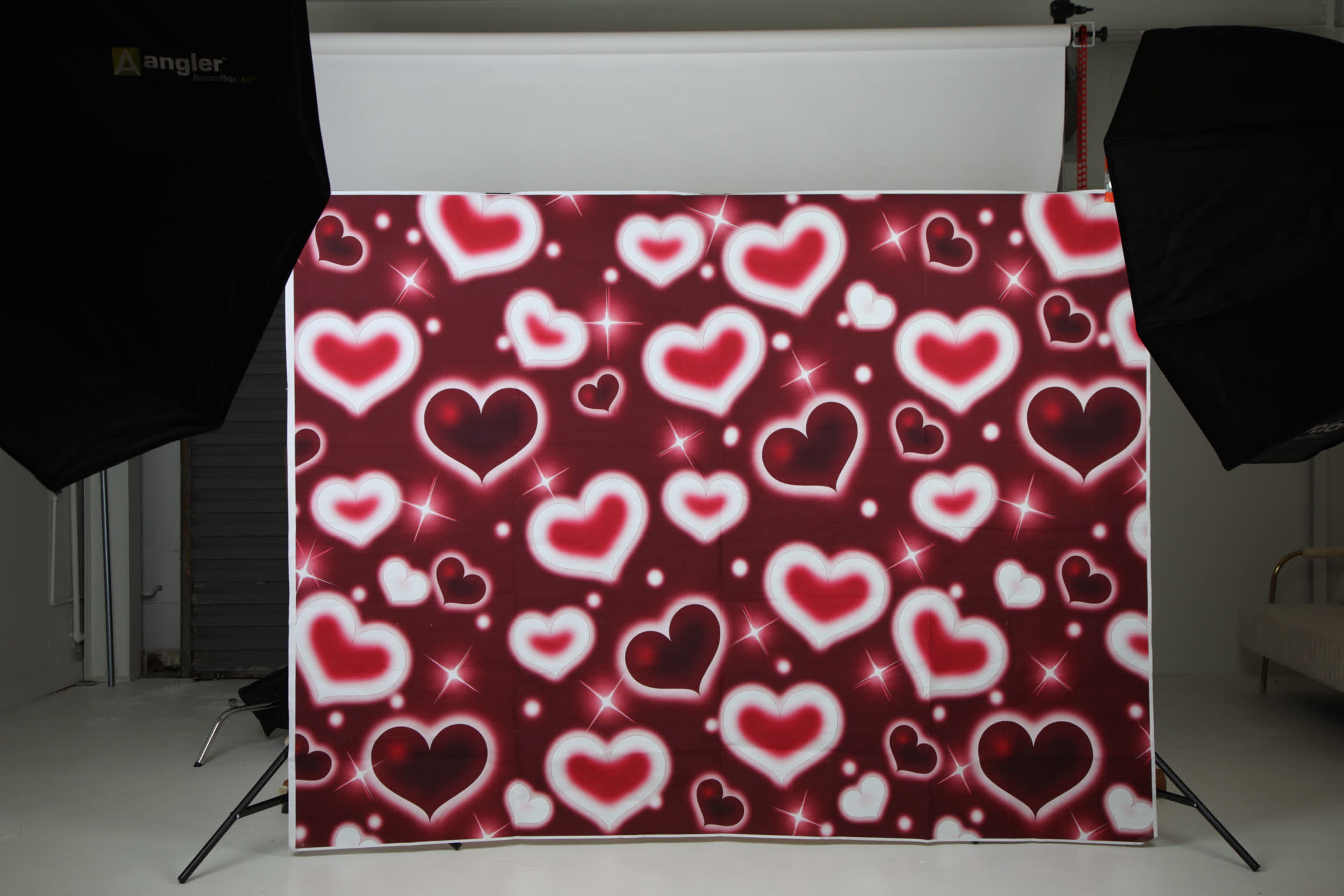 The image features a backdrop adorned with a pattern of red and white hearts against a burgundy background, highlighted by sparkling effects.