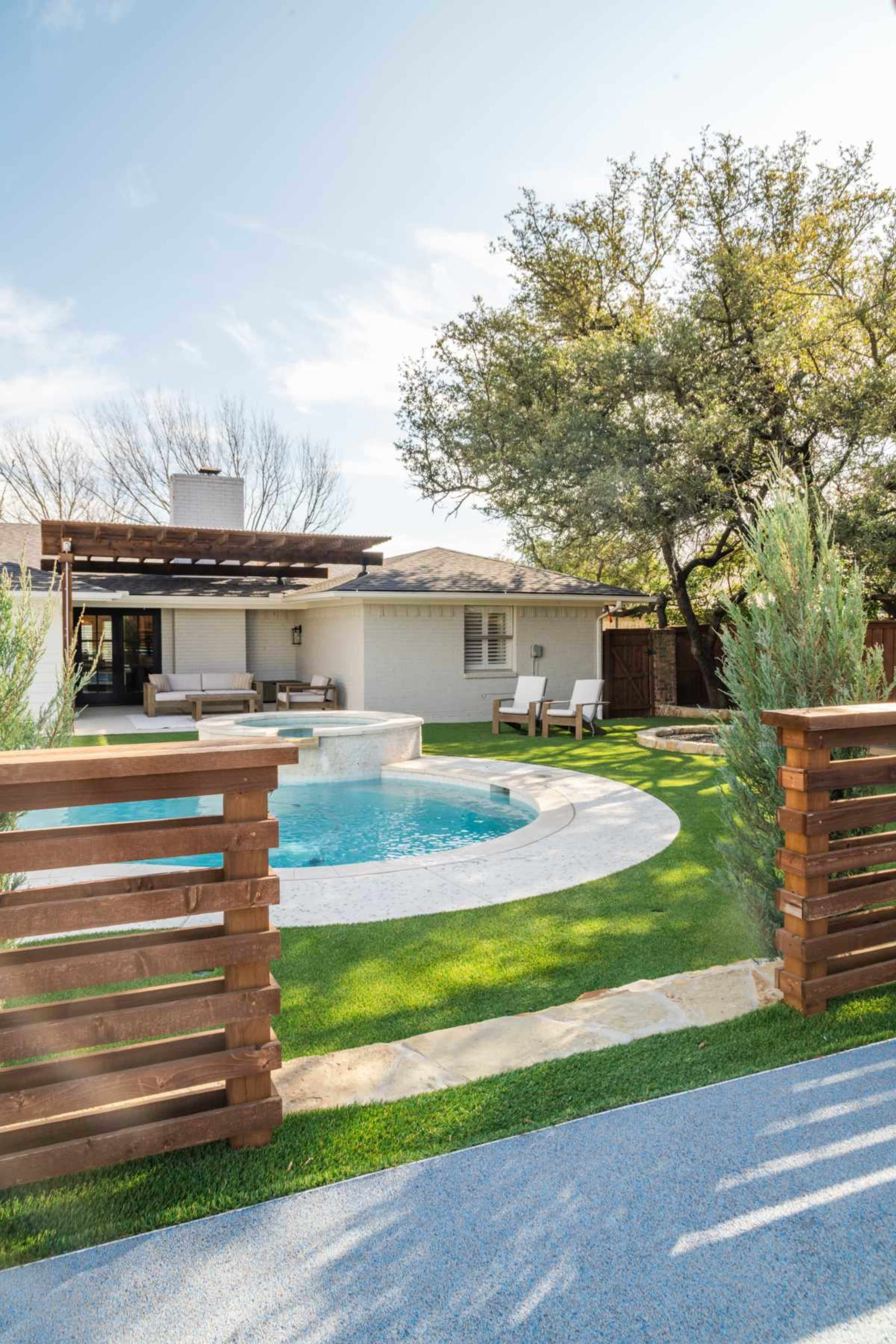 The image shows a backyard with a swimming pool, lounge chairs, and a wooden fence, surrounded by greenery and a house in the background.