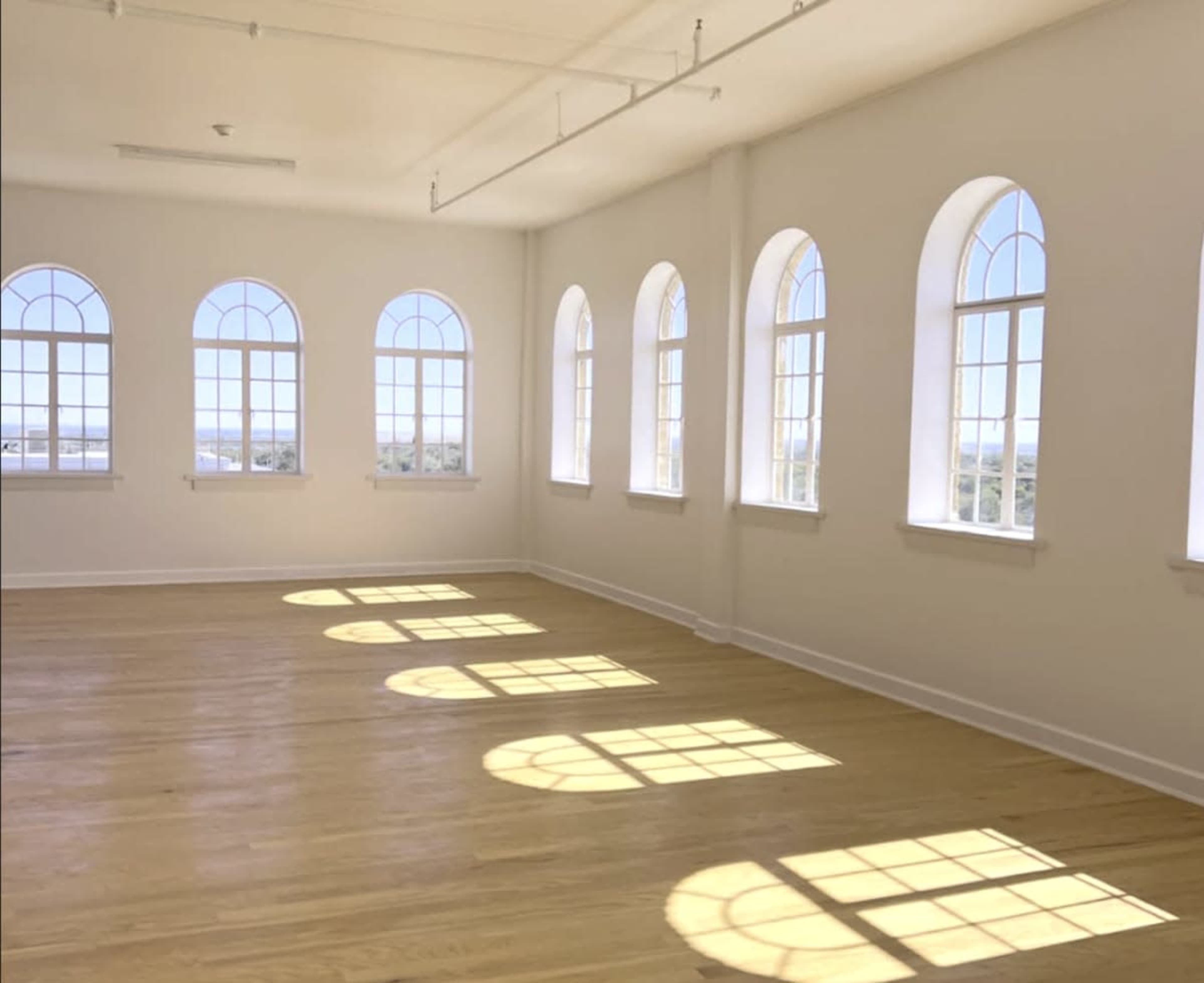 The room features large arched windows that cast elongated shadows on the wooden floor.