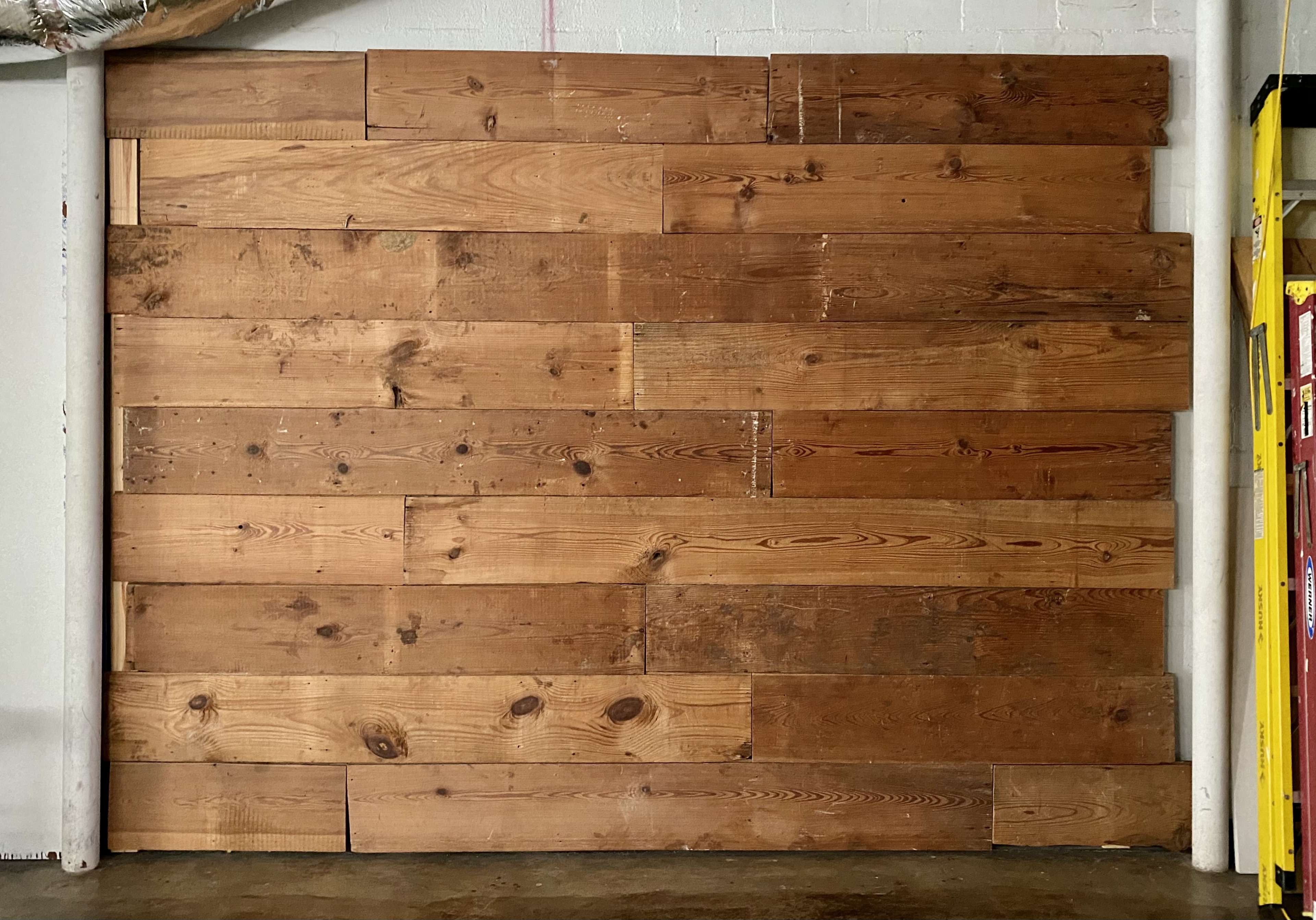A wall constructed from various wooden planks arranged horizontally.