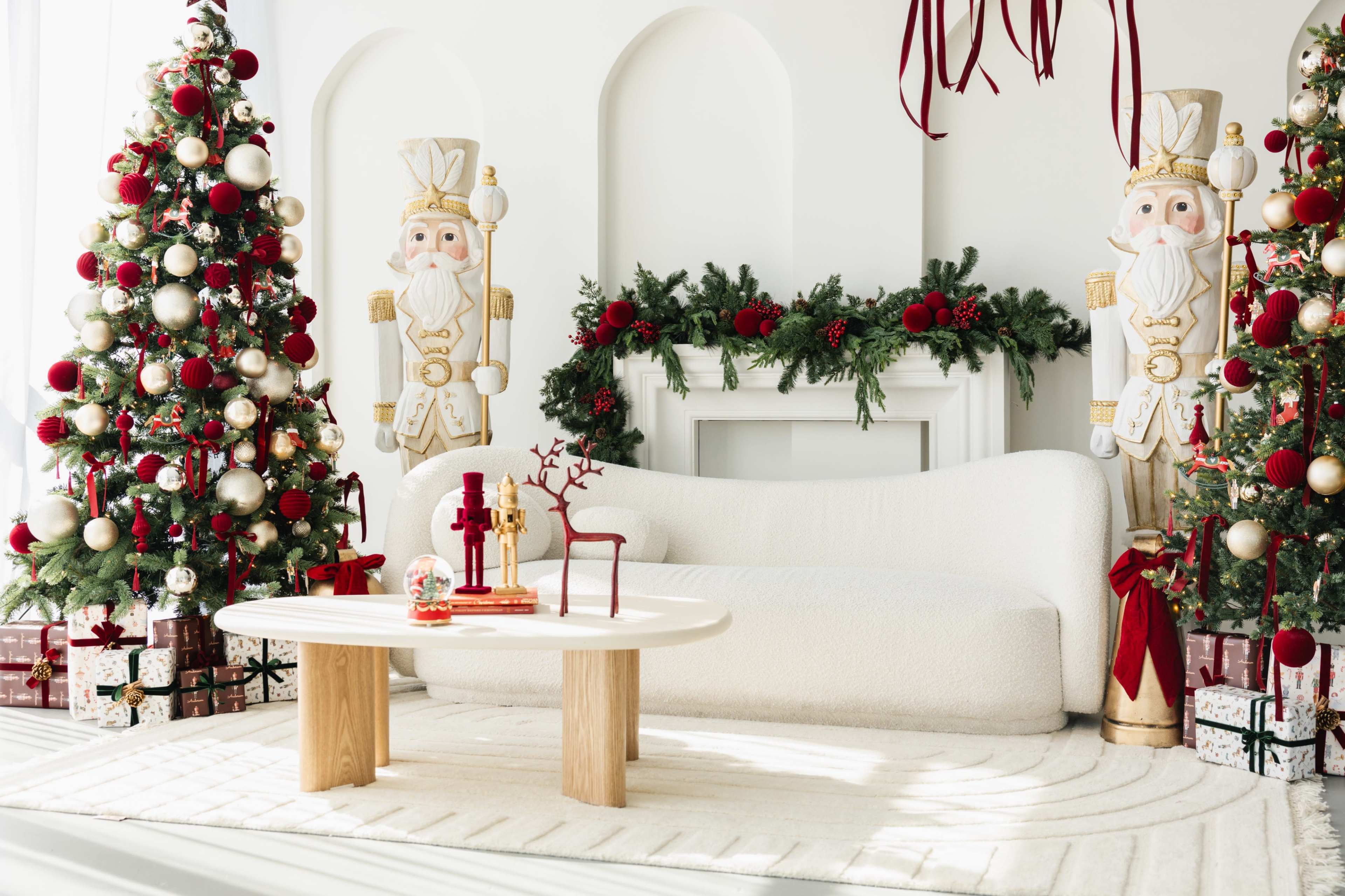 The image features a festive living room decorated for Christmas, with a white couch, two Christmas trees adorned with ornaments, and nutcracker sculptures flanking a fireplace.