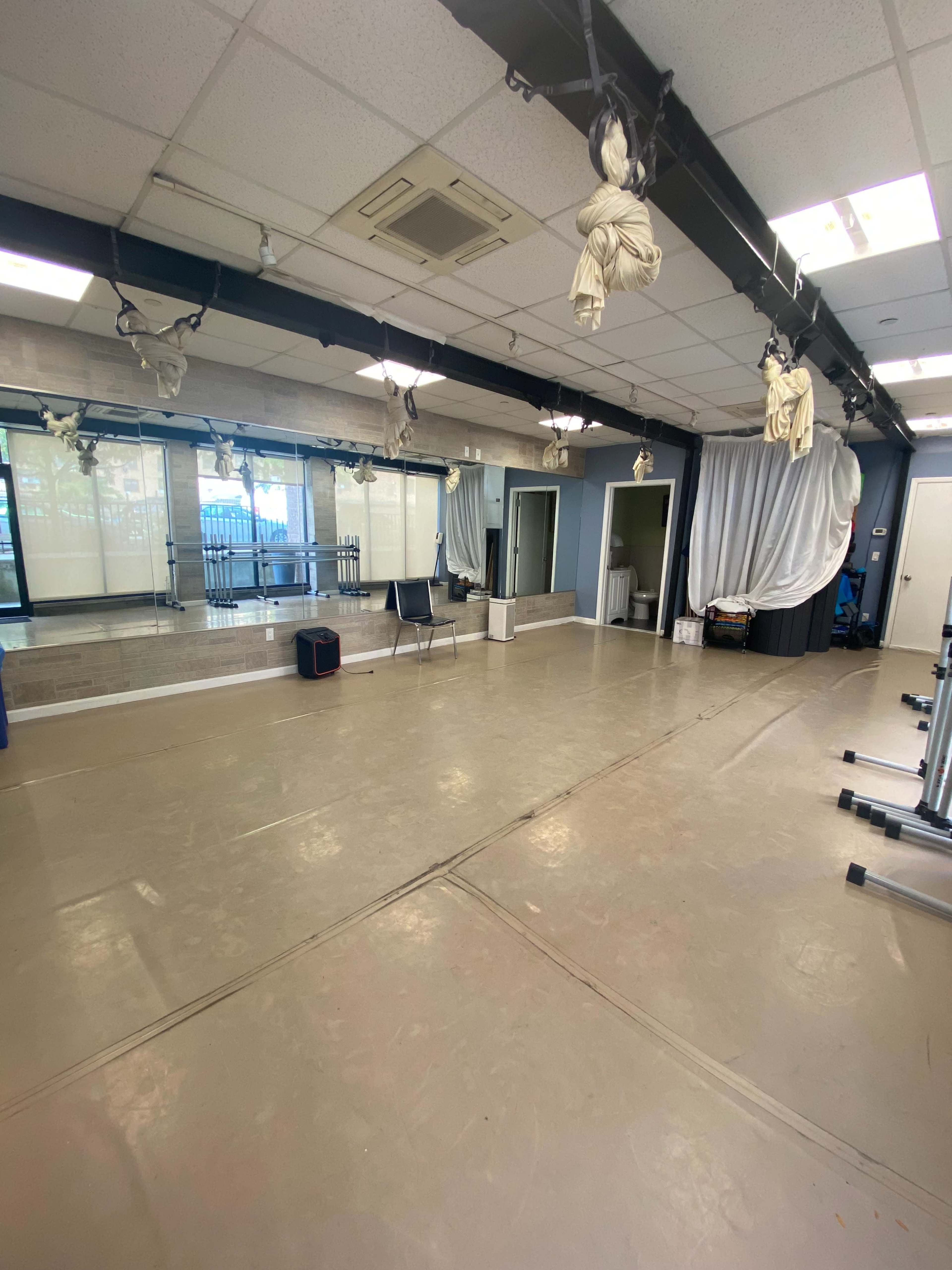 The image shows a spacious rehearsal room with mirrors, lighting fixtures, and various equipment set up against the walls.