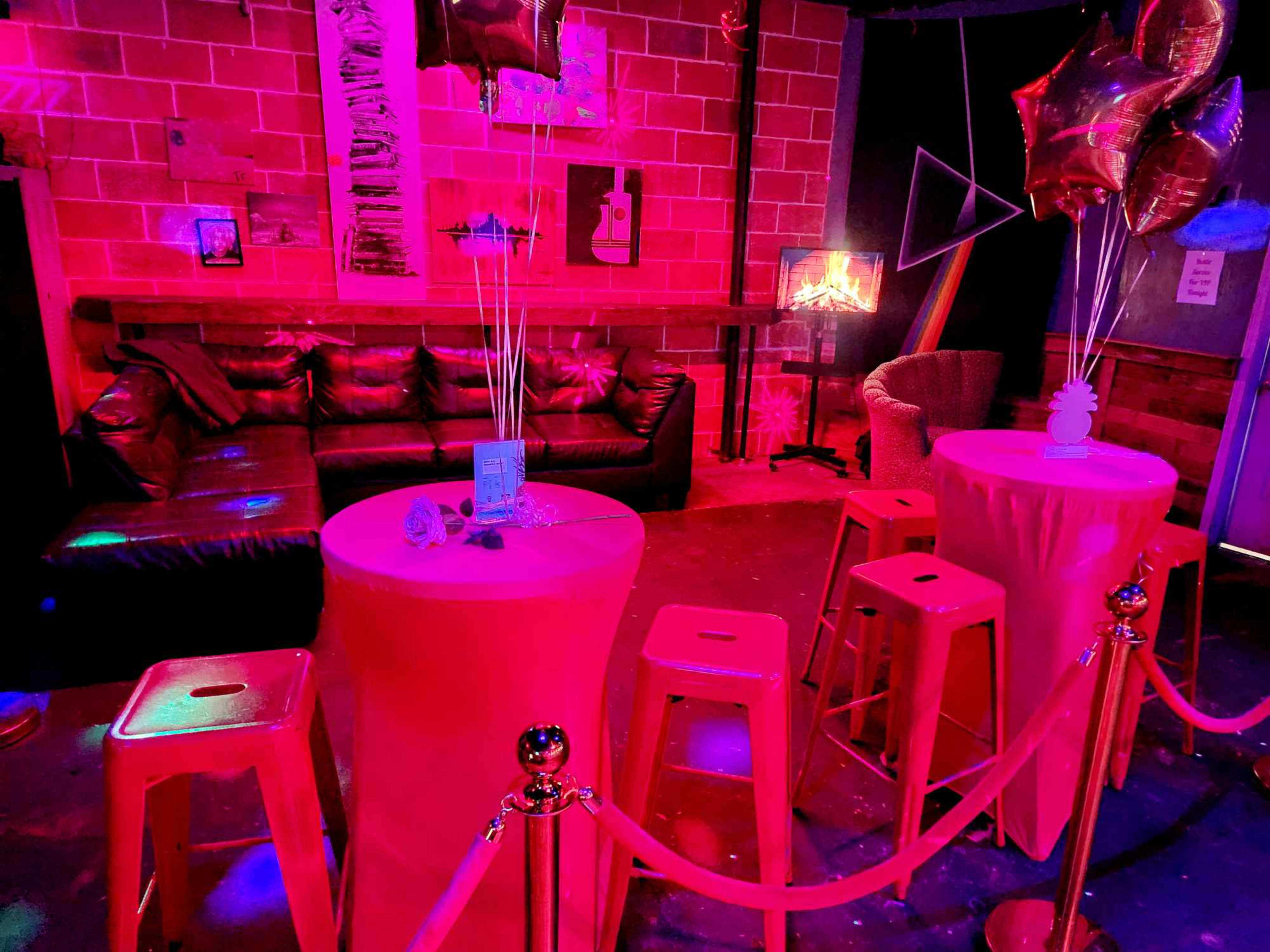 The scene features a colorful nightclub setting with pink lighting, decorated tables, and balloons, along with a cozy seating area in the background.