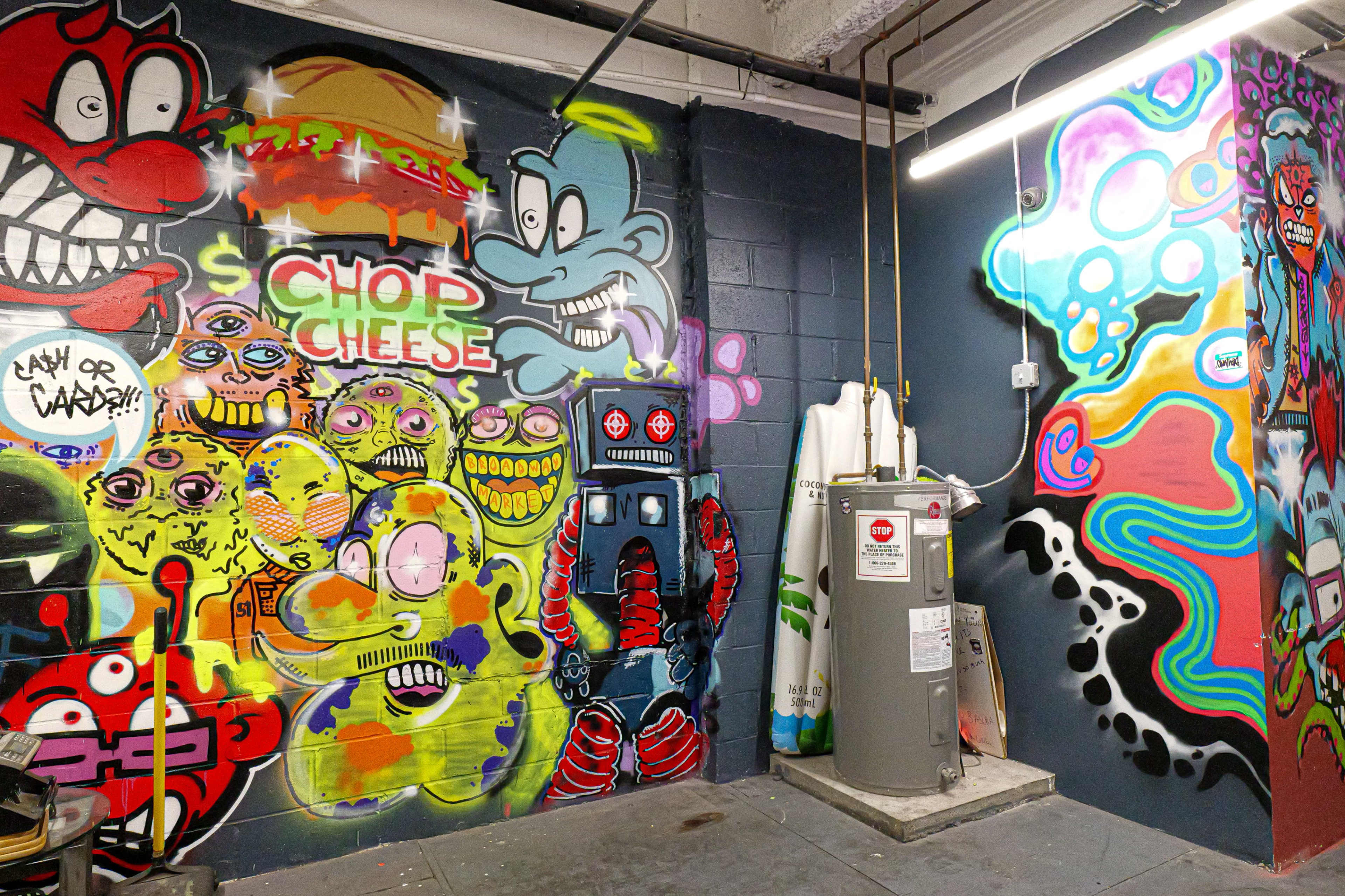 The image shows a corner of a room adorned with colorful graffiti featuring various cartoonish characters and designs on the walls.
