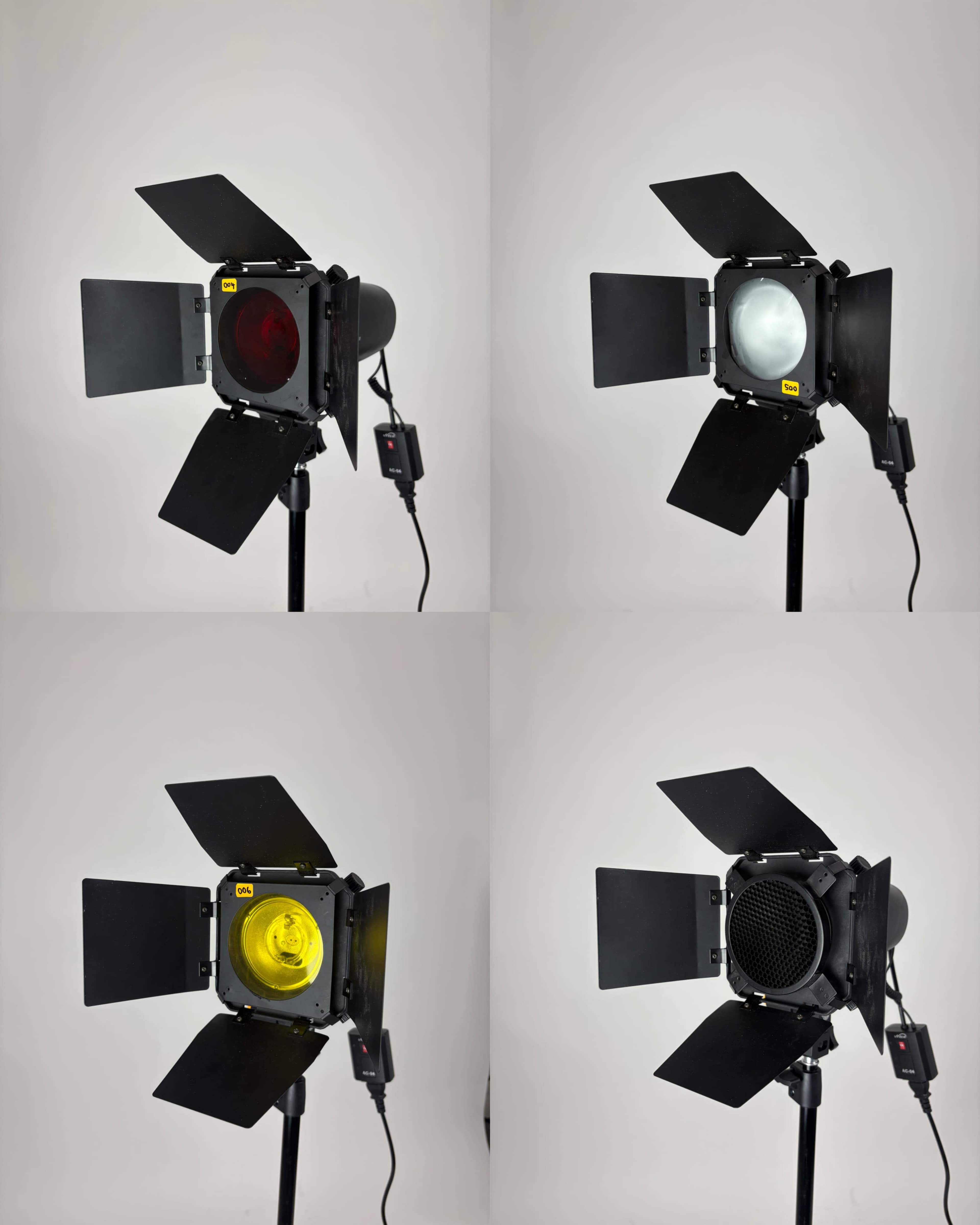 The image shows four different lighting devices, each with distinct colored filters: red, white, yellow, and a mesh screen, all mounted on adjustable stands.