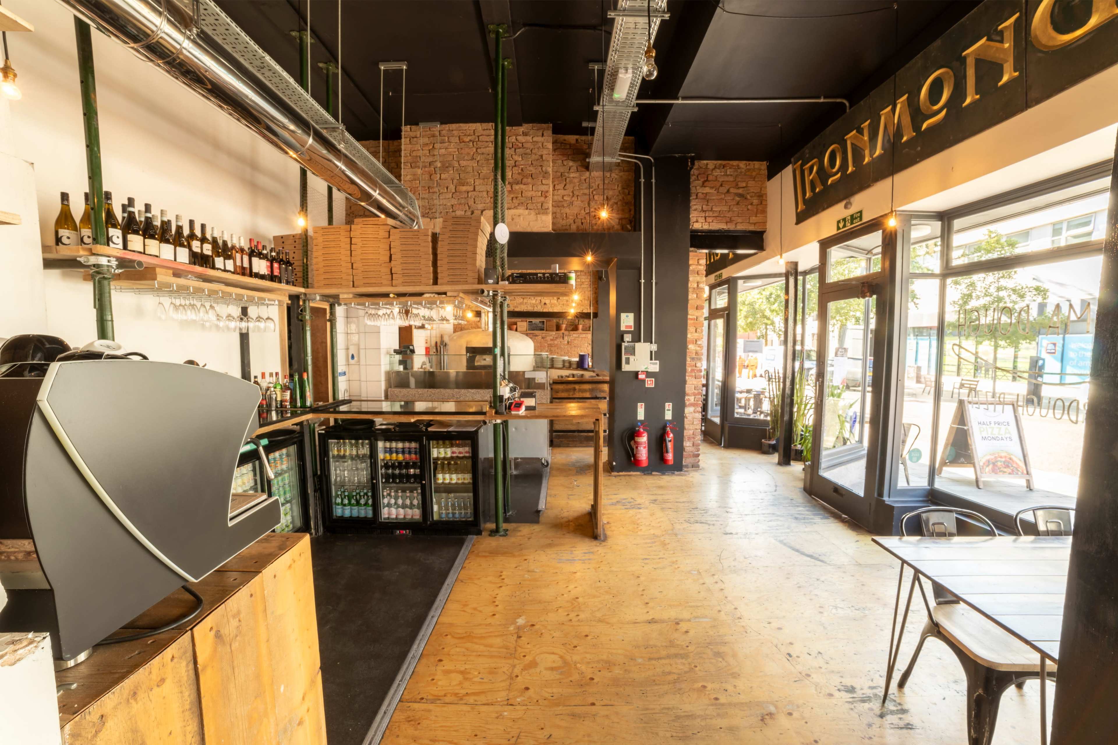 Rustic pizza restaurant with high ceilings and windows spanning the venue. Image in South Norwood, London, ENG