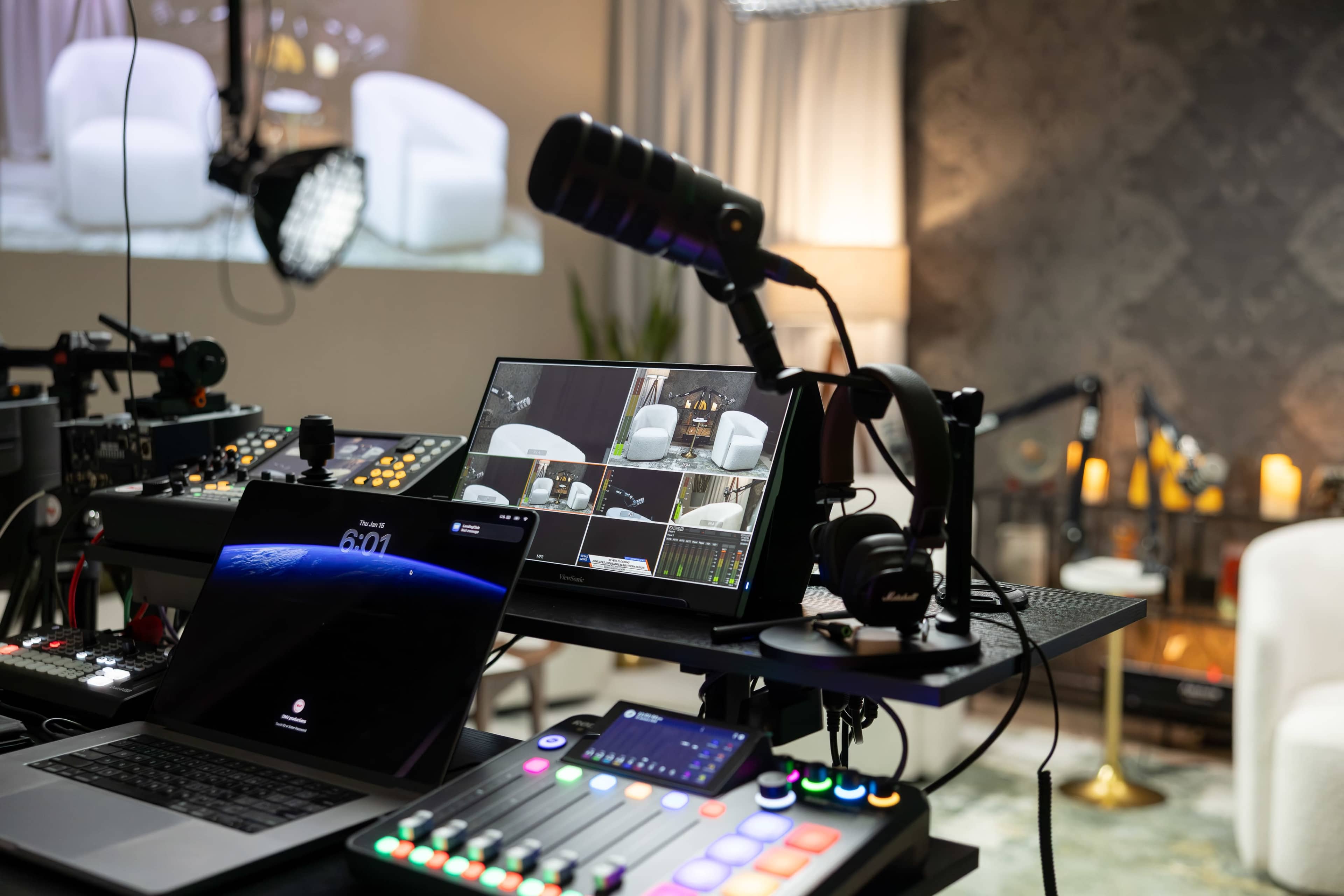 The image shows a multimedia setup featuring multiple monitors, audio equipment, and control interfaces in a modern studio environment.